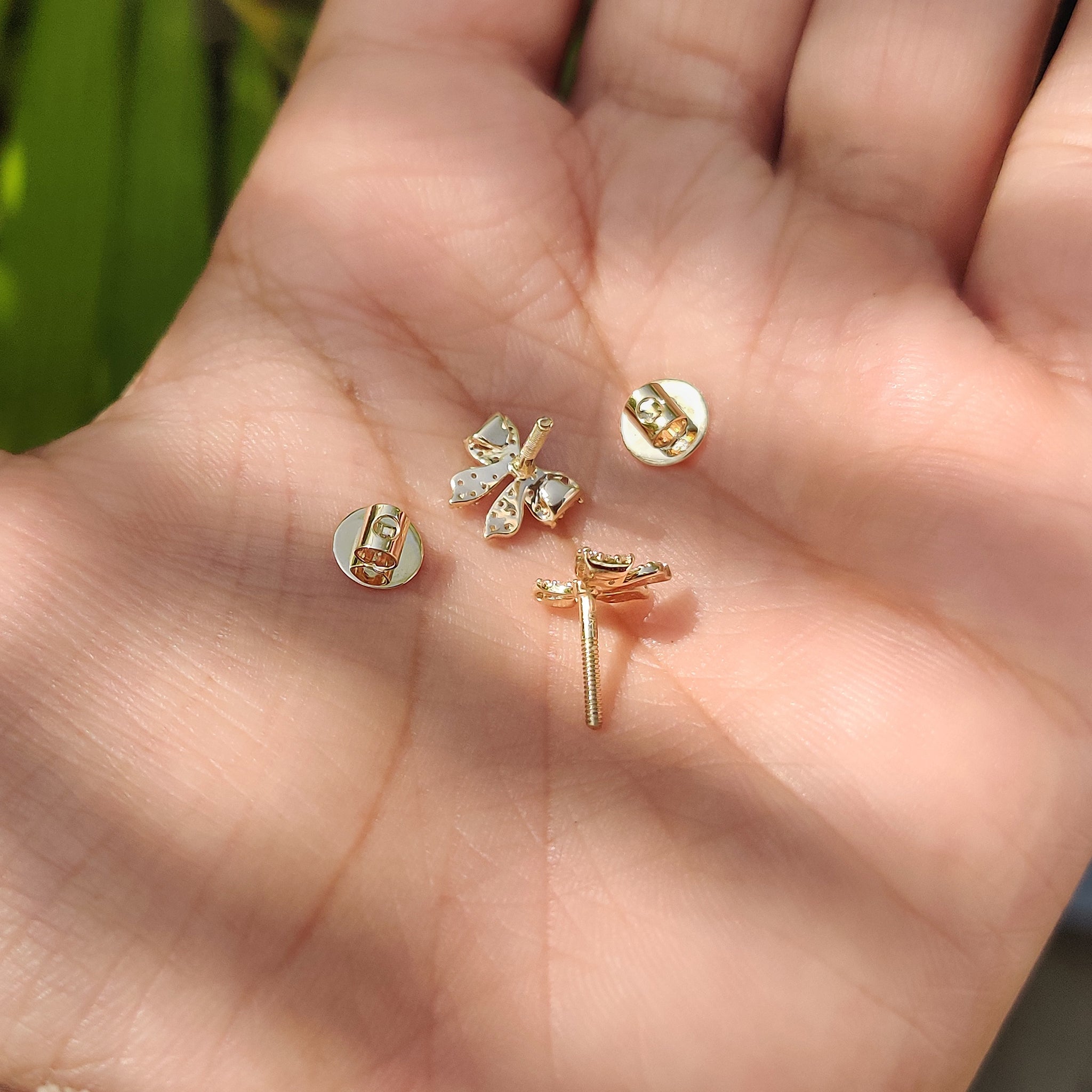 Cute gold bow stud earrings with sparkling round cut diamonds
