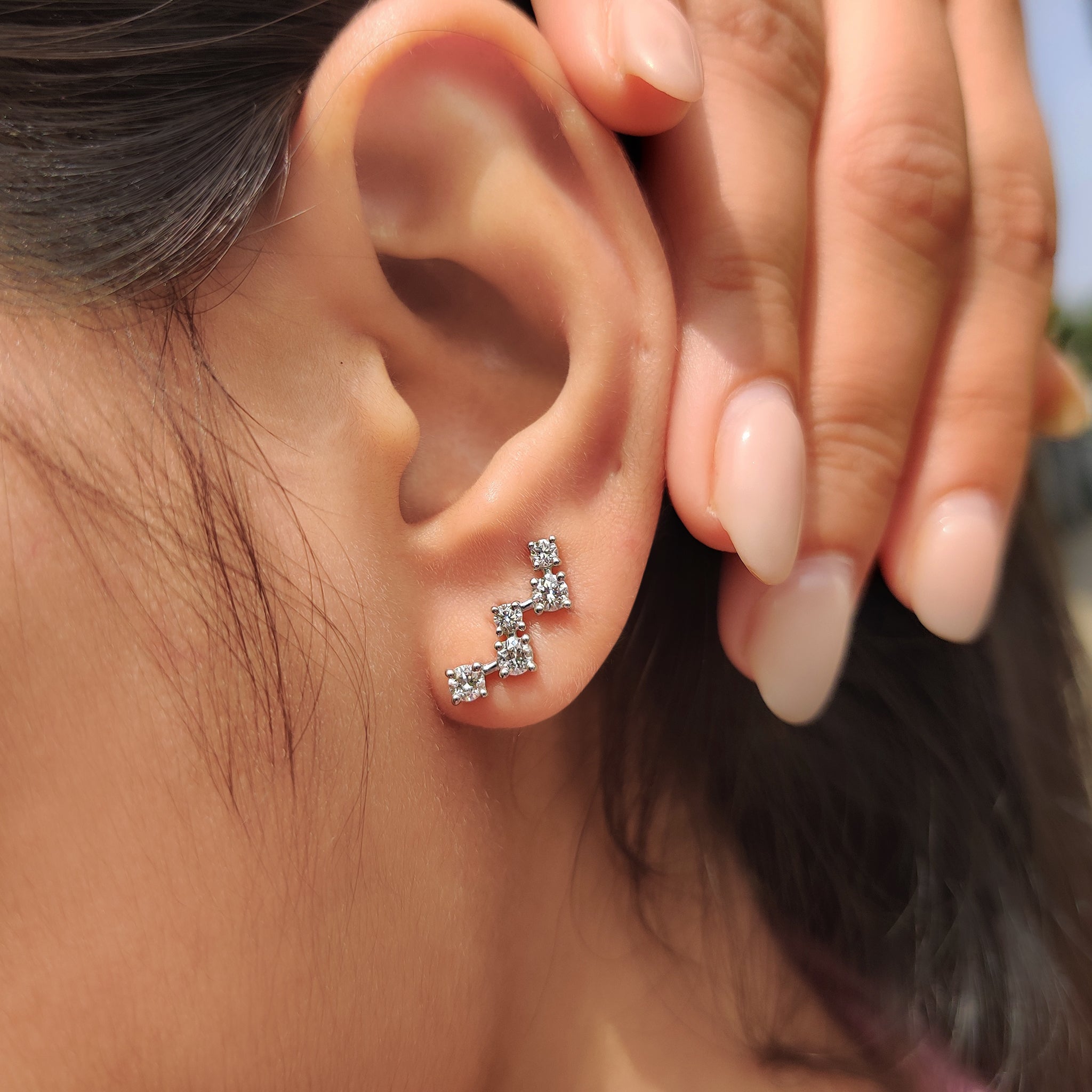 Stud earrings featuring round cut diamonds and white gold finish
