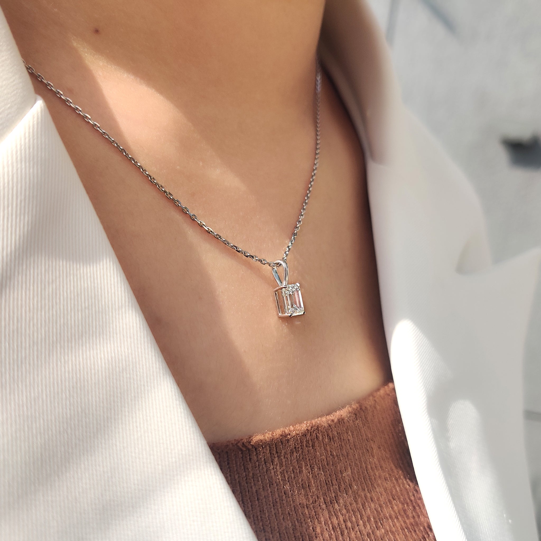 Carat diamonds pendant with solitaire emerald cut diamond in white gold
