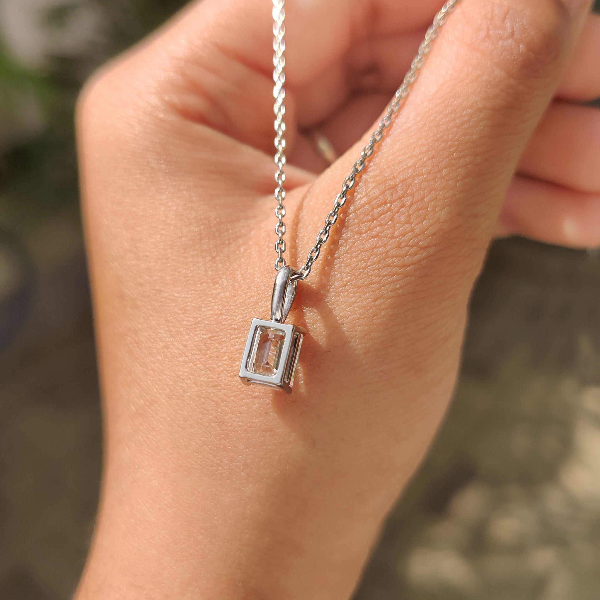 Solitaire emerald cut pendant with carat diamonds and secure prong setting
