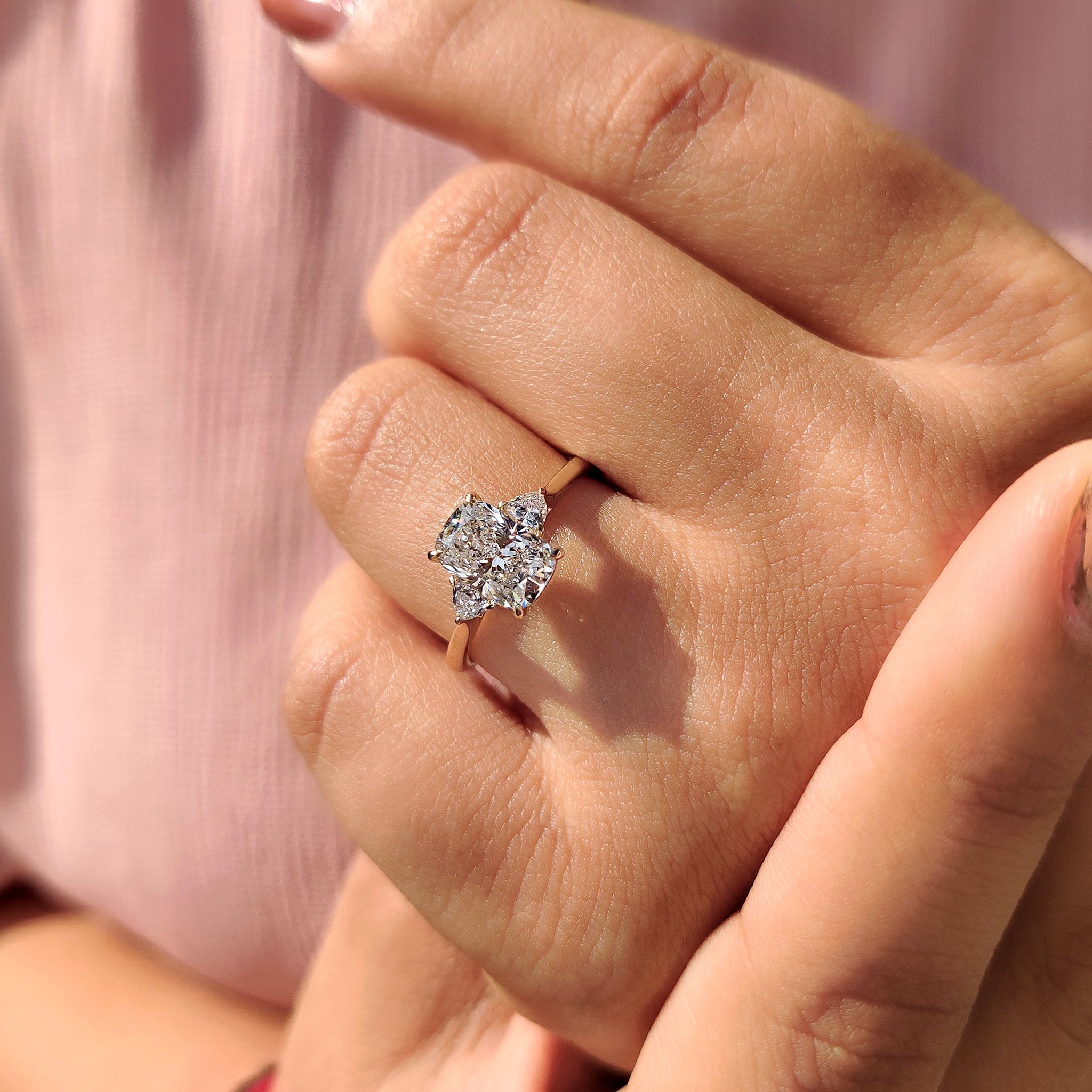 Yellow gold elongated cushion cut diamond ring with cathedral setting.
