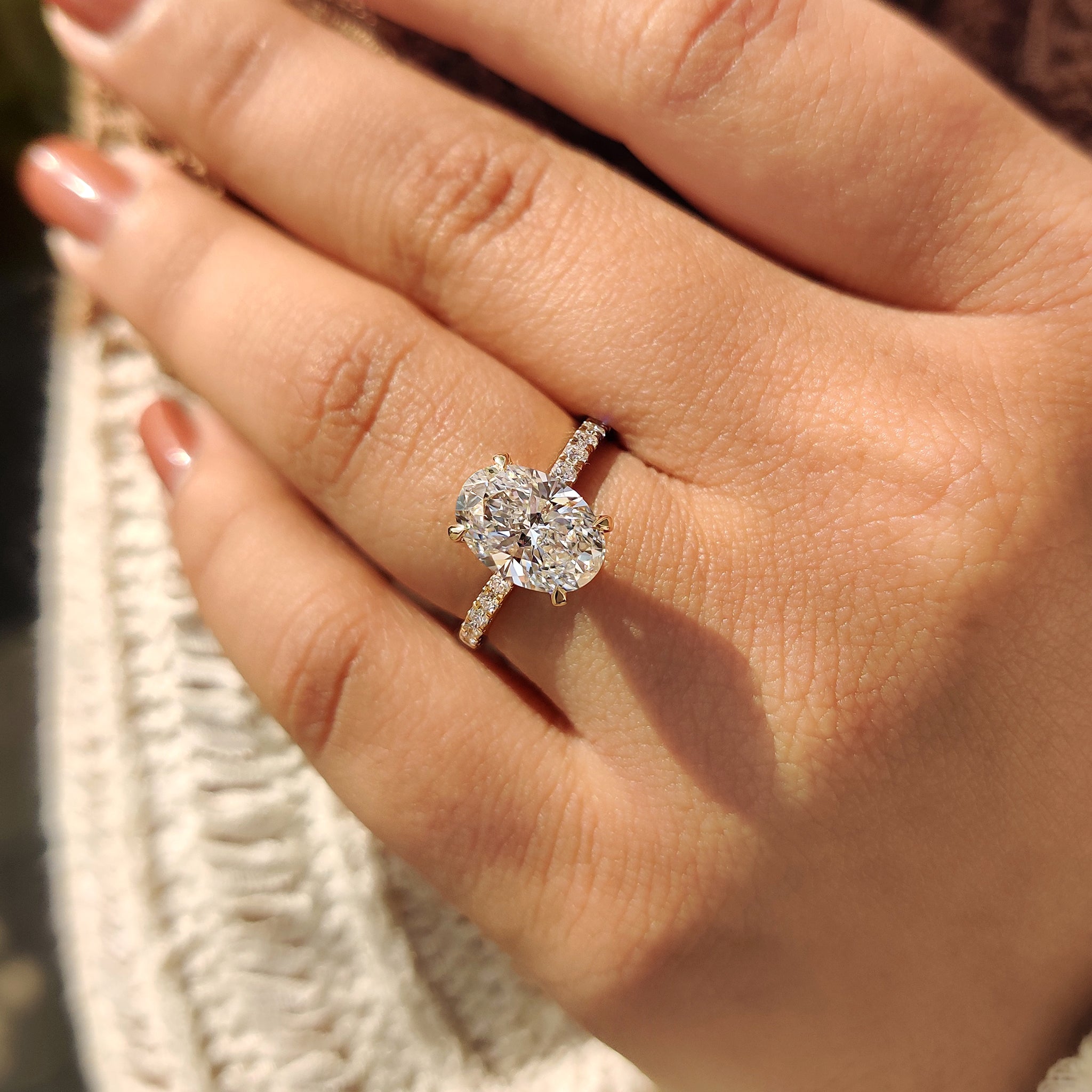 Handmade jewelry oval diamond ring with pave band and hidden halo in yellow gold.