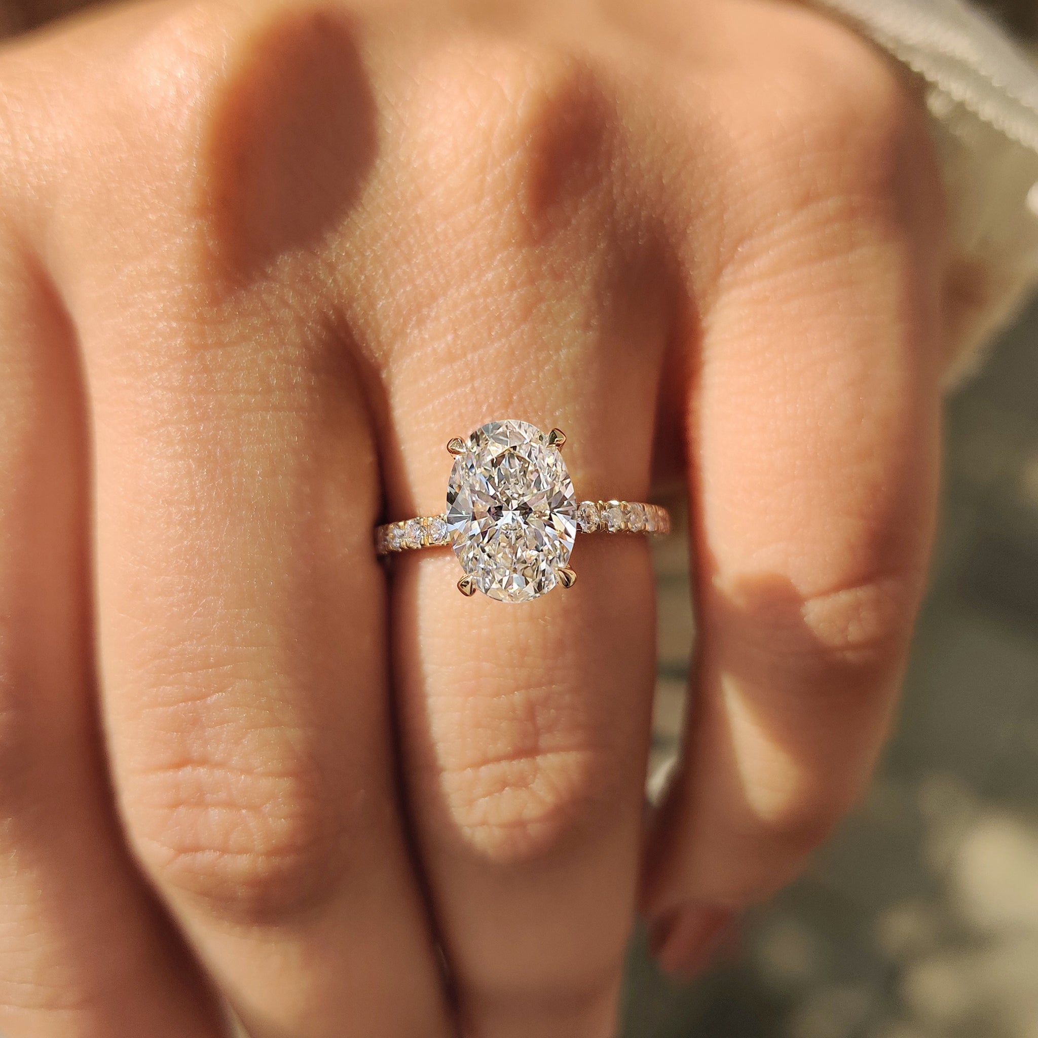 Diamond engagement ring with round cut pave setting and yellow gold oval band.