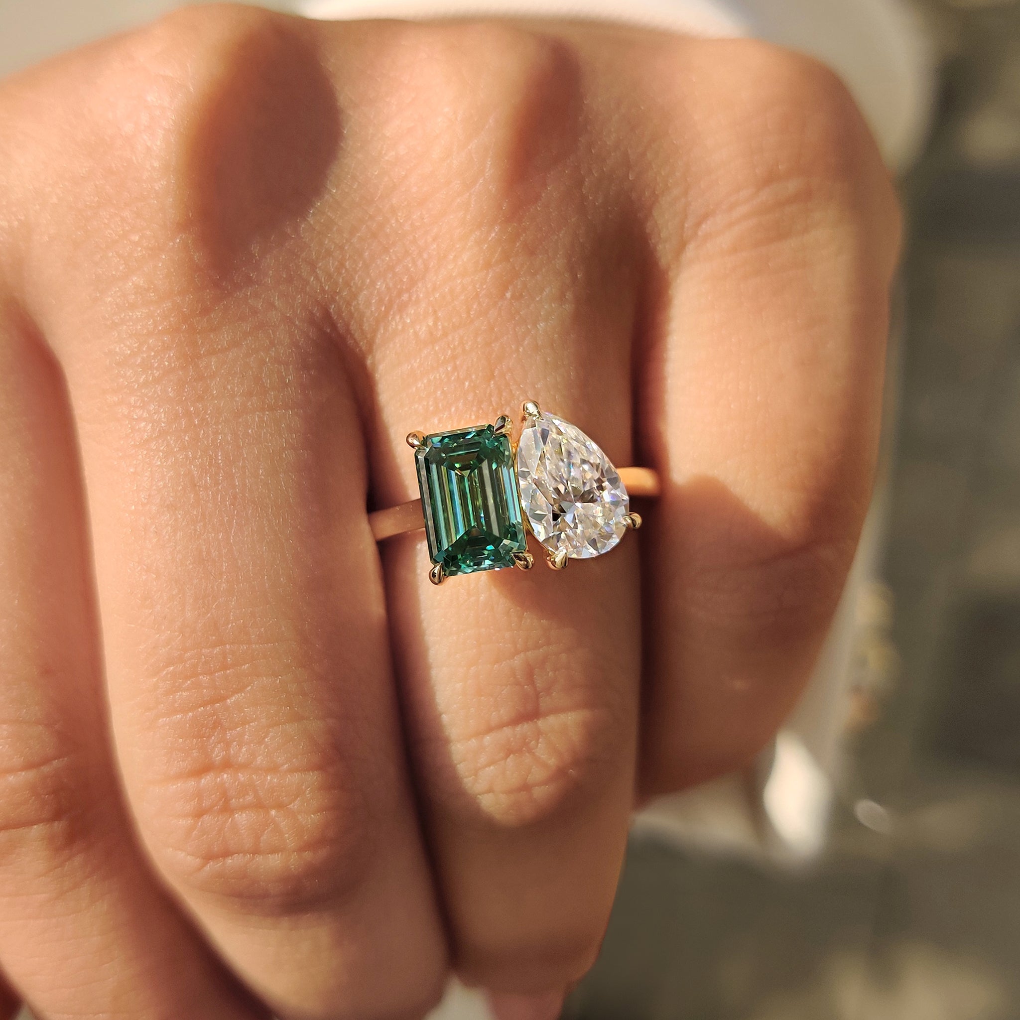 Handmade jewelry engagement ring with pear and emerald stones in yellow gold.