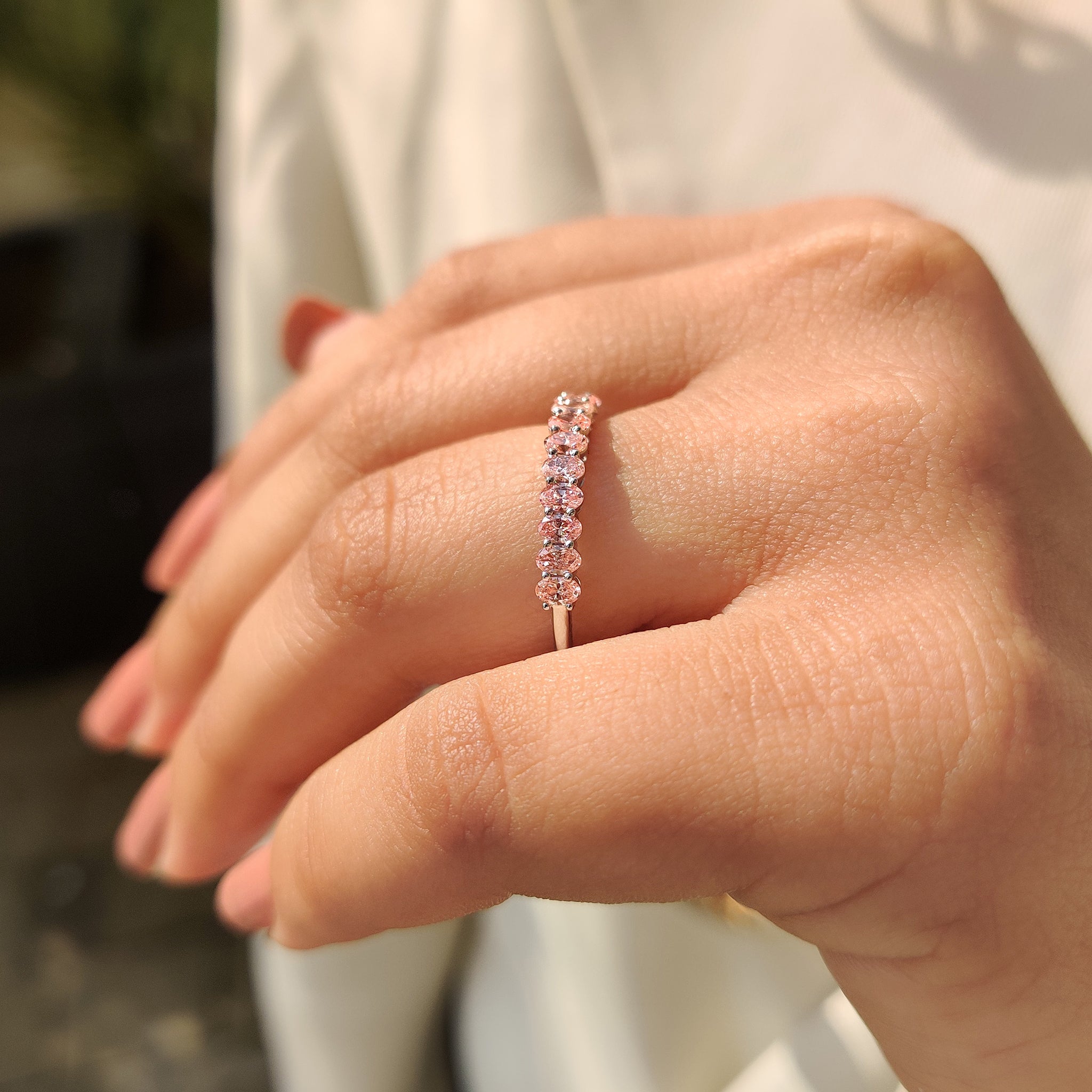 Custom white gold wedding band with pink oval cut diamond and carat diamonds.