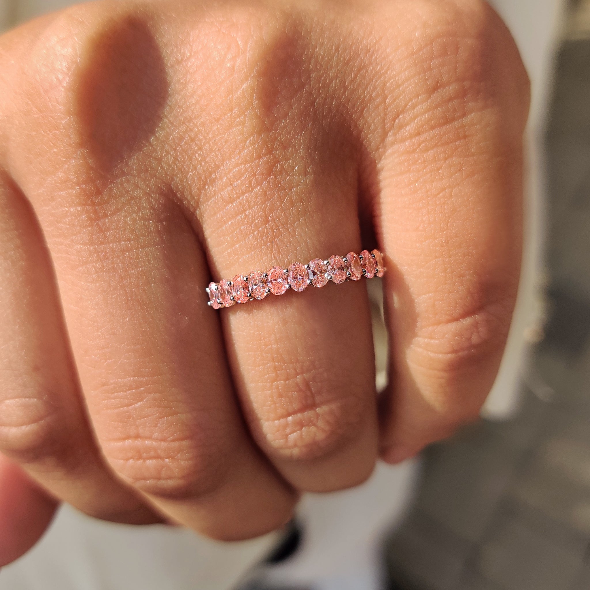 Custom wedding band with pink diamond, shared prong setting, and handmade craftsmanship.