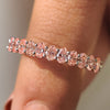 Pink diamond wedding band in white gold with half eternity design and shared prong setting.