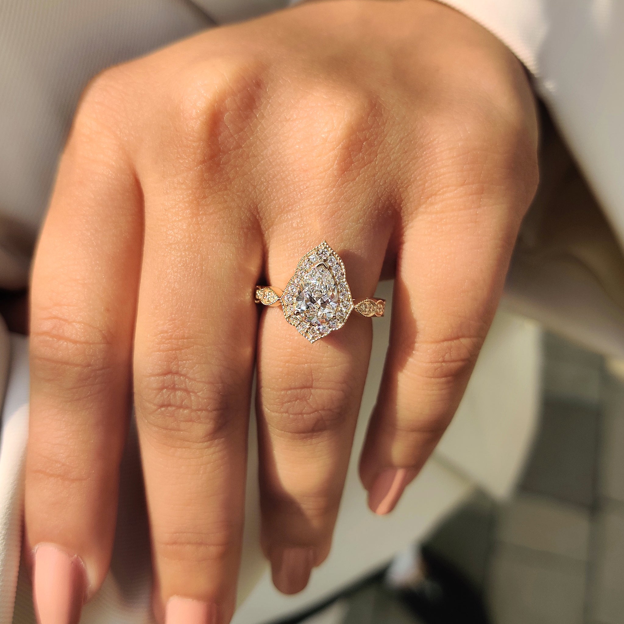Lab grown diamond ring with pear halo design and cathedral setting.
