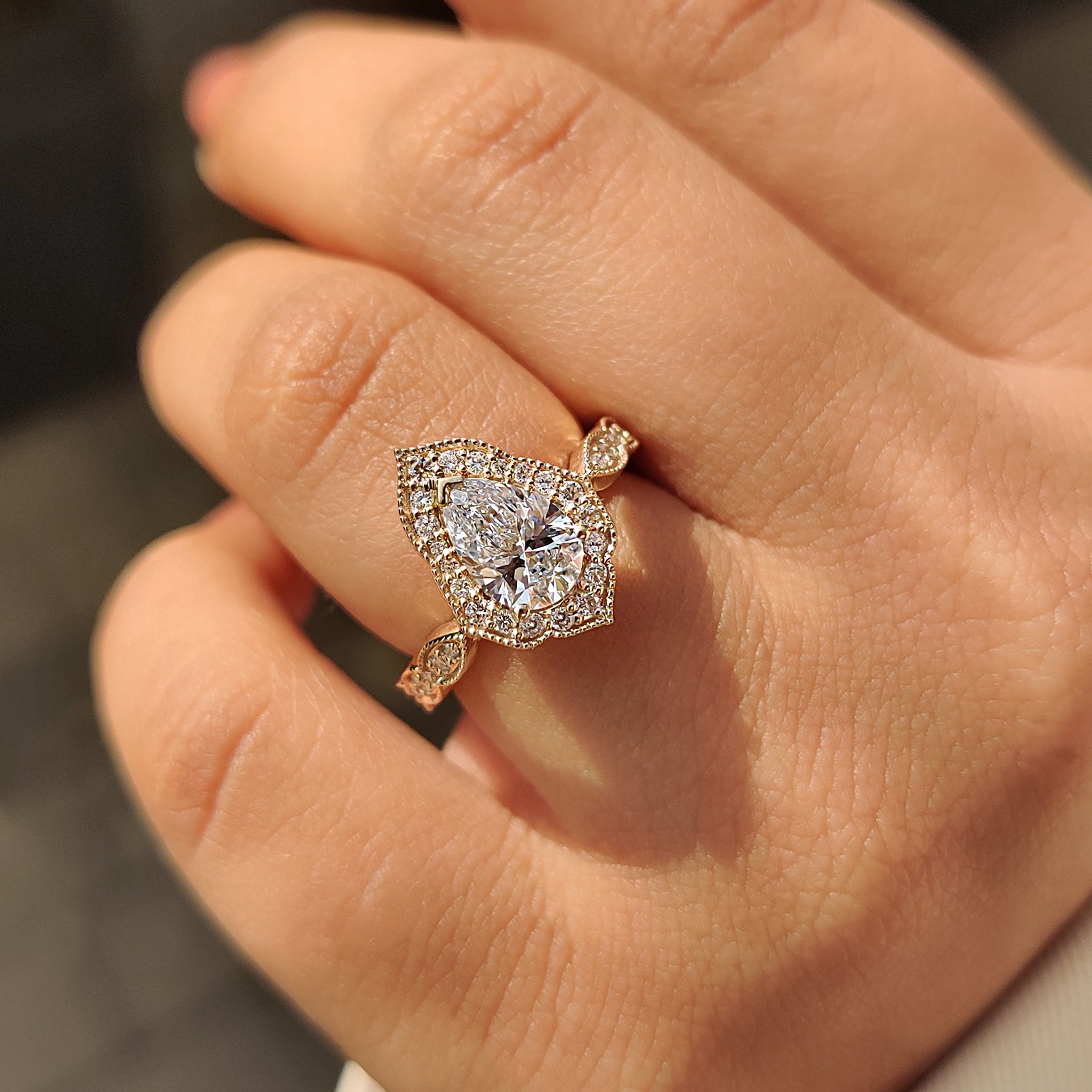 IGI certified vintage engagement ring with round cut halo and pear cut diamond.
