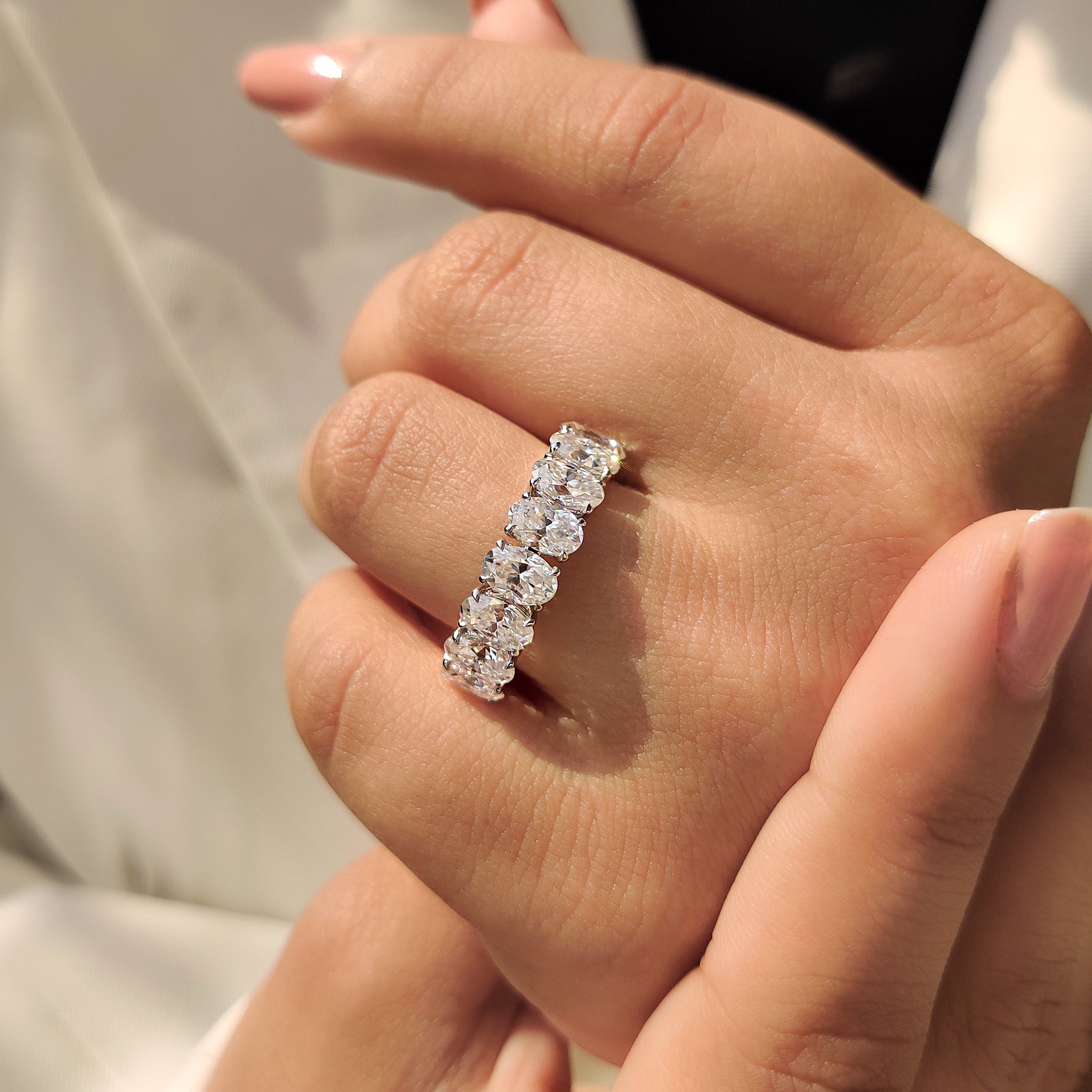 Carat diamonds wedding band with eight stone oval Moissanite in white gold.
