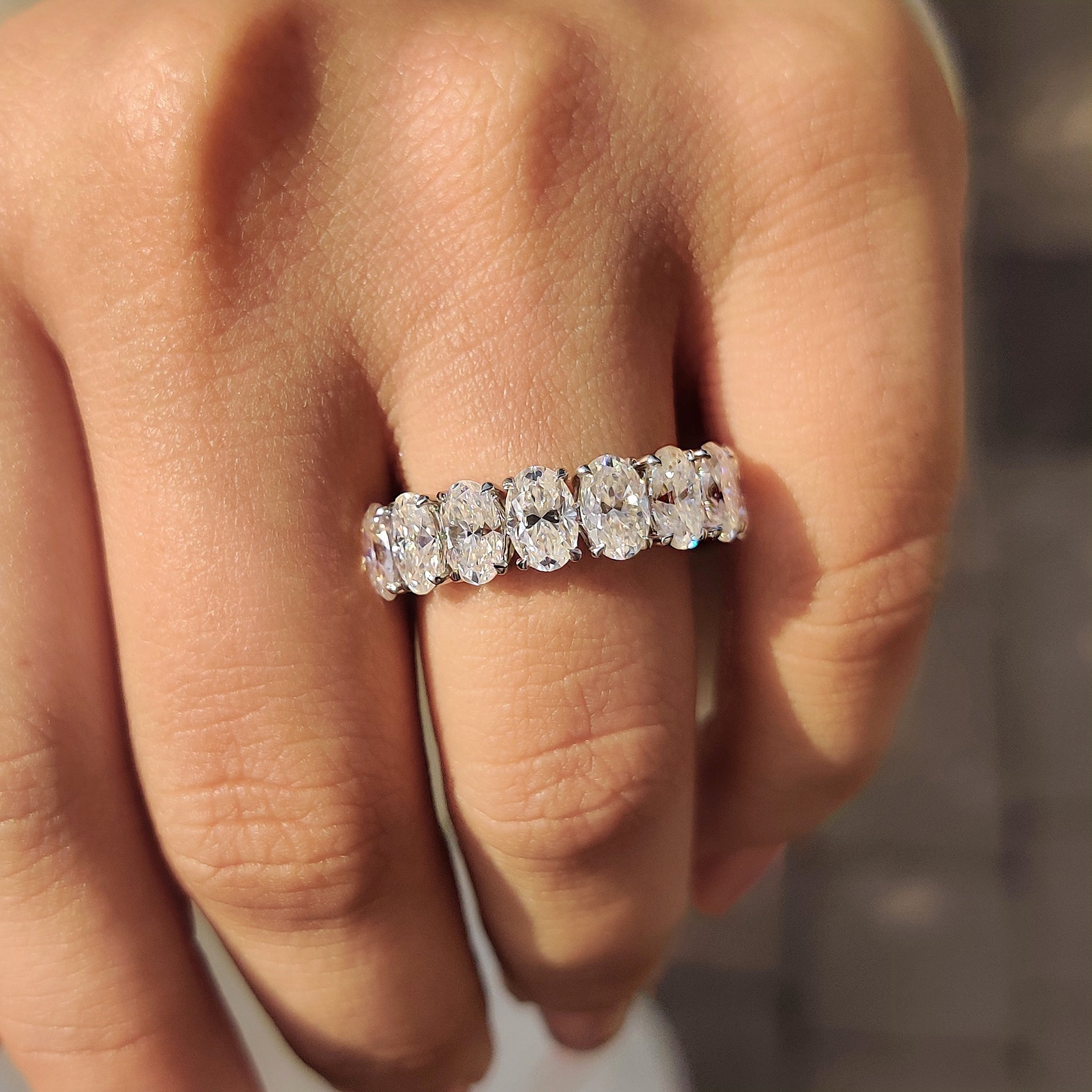 Moissanite wedding band with custom design and claw prong setting.
