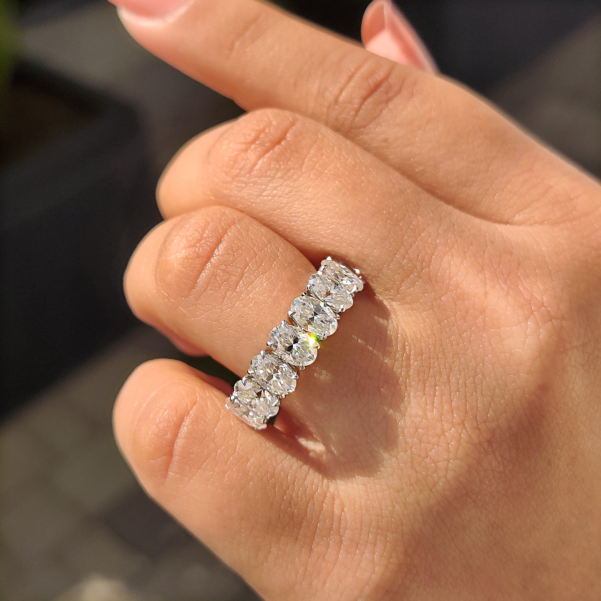 Eight stone half eternity wedding band with oval Moissanite and claw prong setting.
