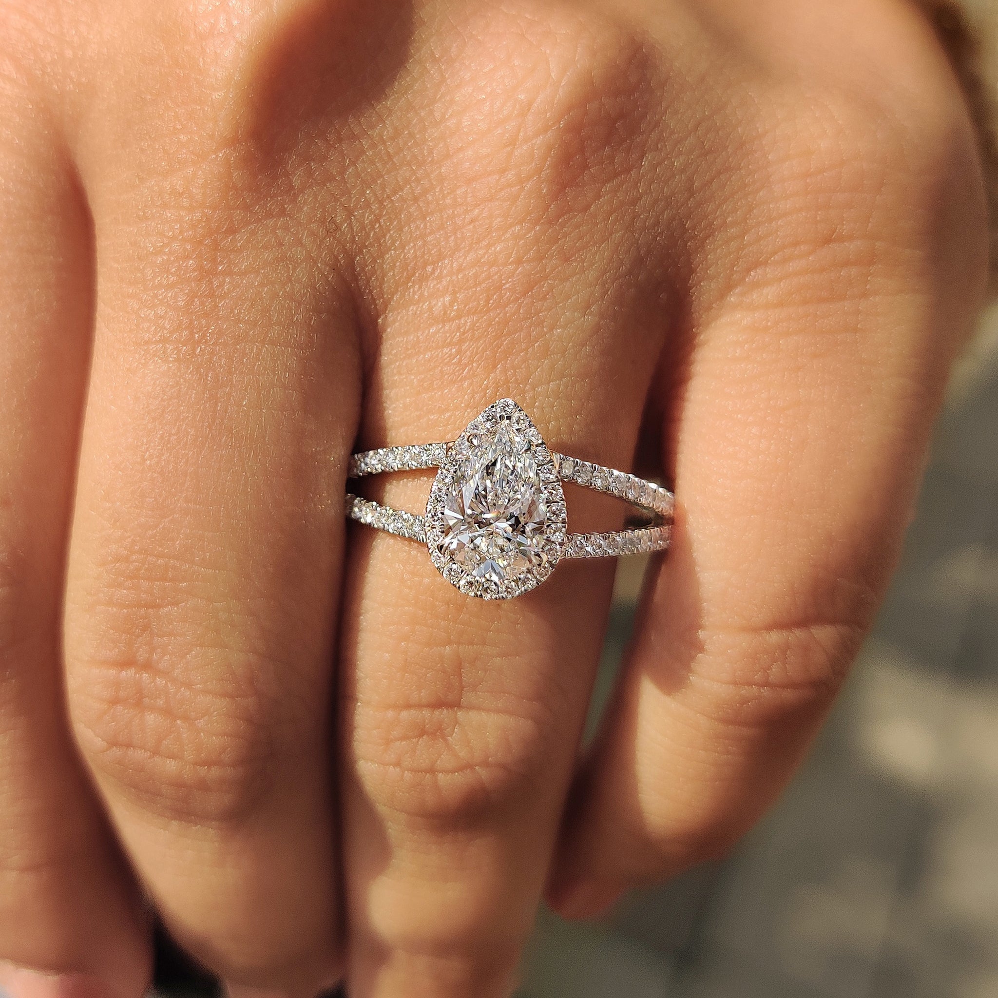 Lab grown diamond ring with pear cut center and round cut halo in white gold.
