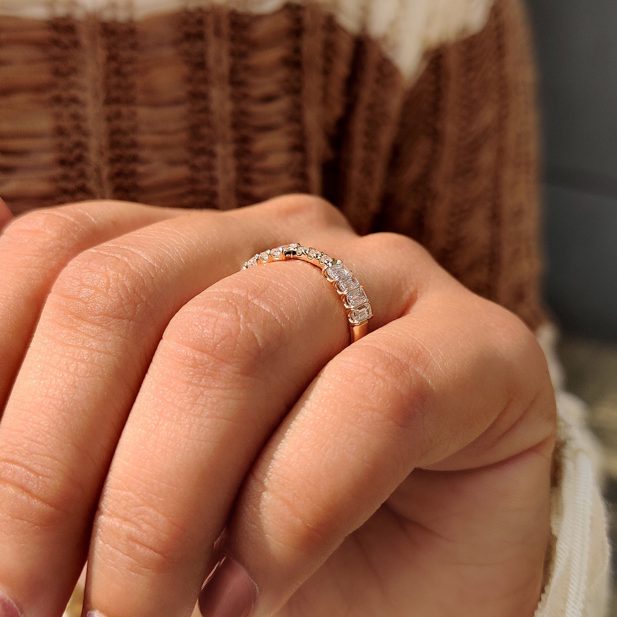 Lab grown diamond stackable wedding band with emerald and round stones.
