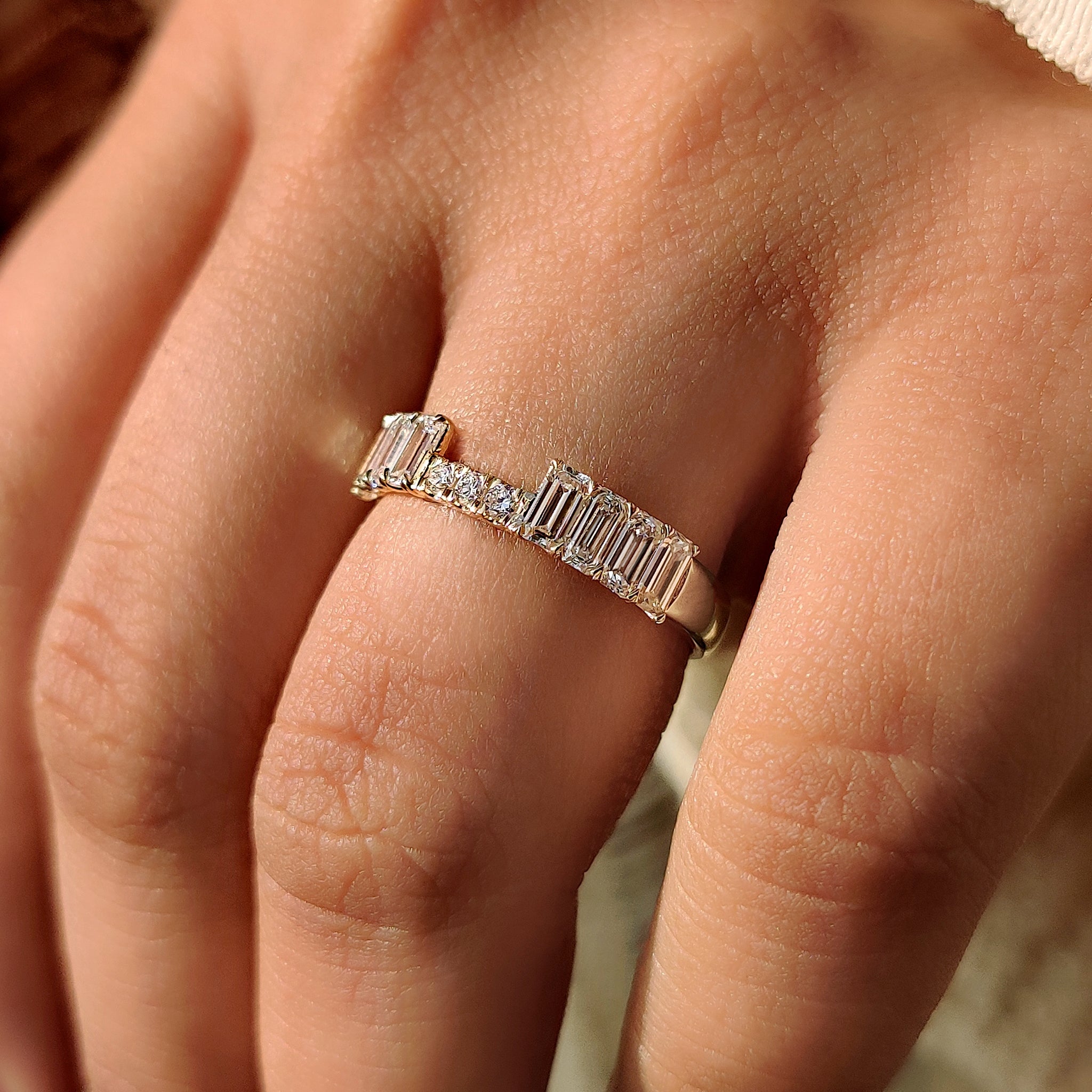 Emerald and round diamond stackable band with secure claw prong setting.
