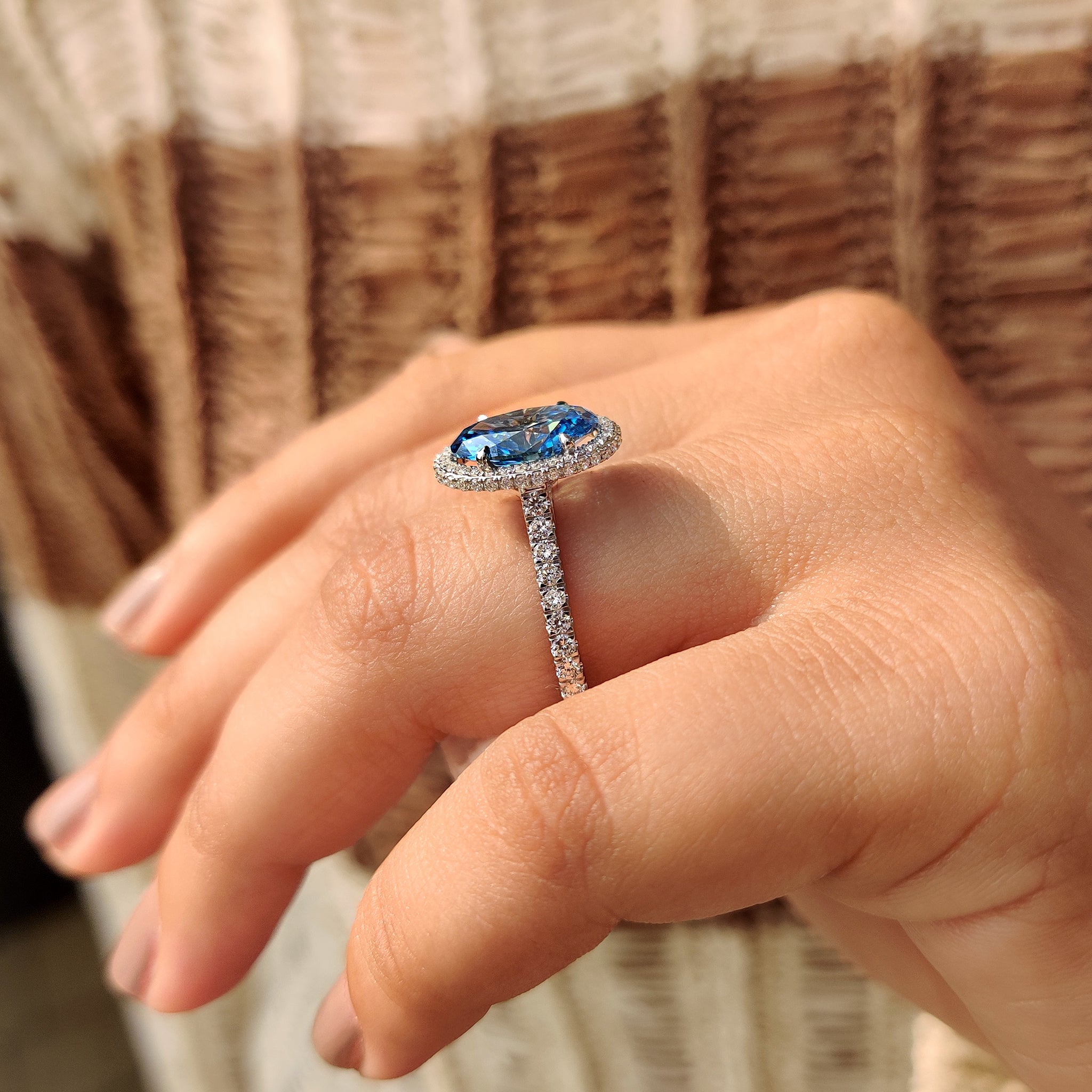 Oval blue stone engagement ring with four claw setting
