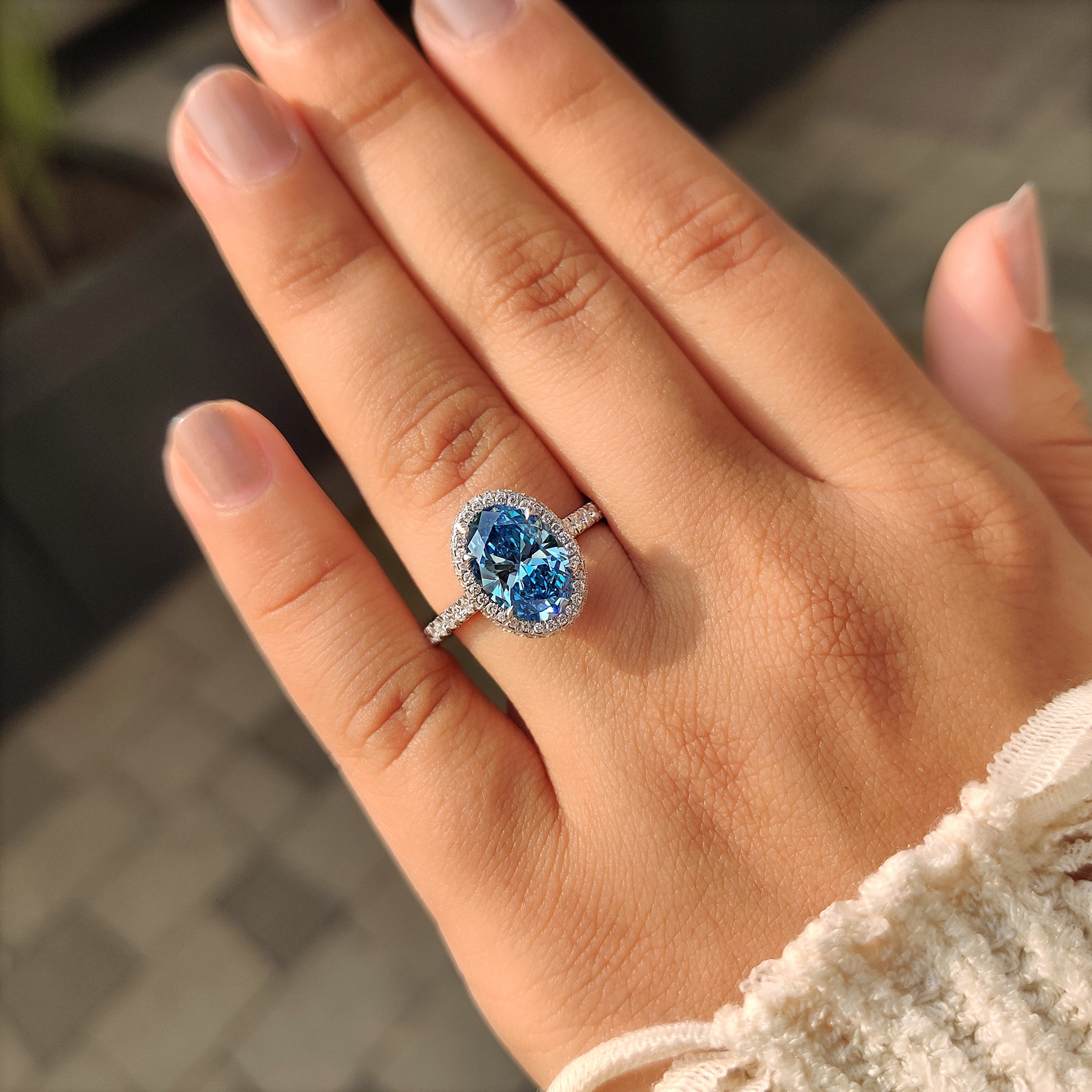 White gold blue diamond ring with halo setting
