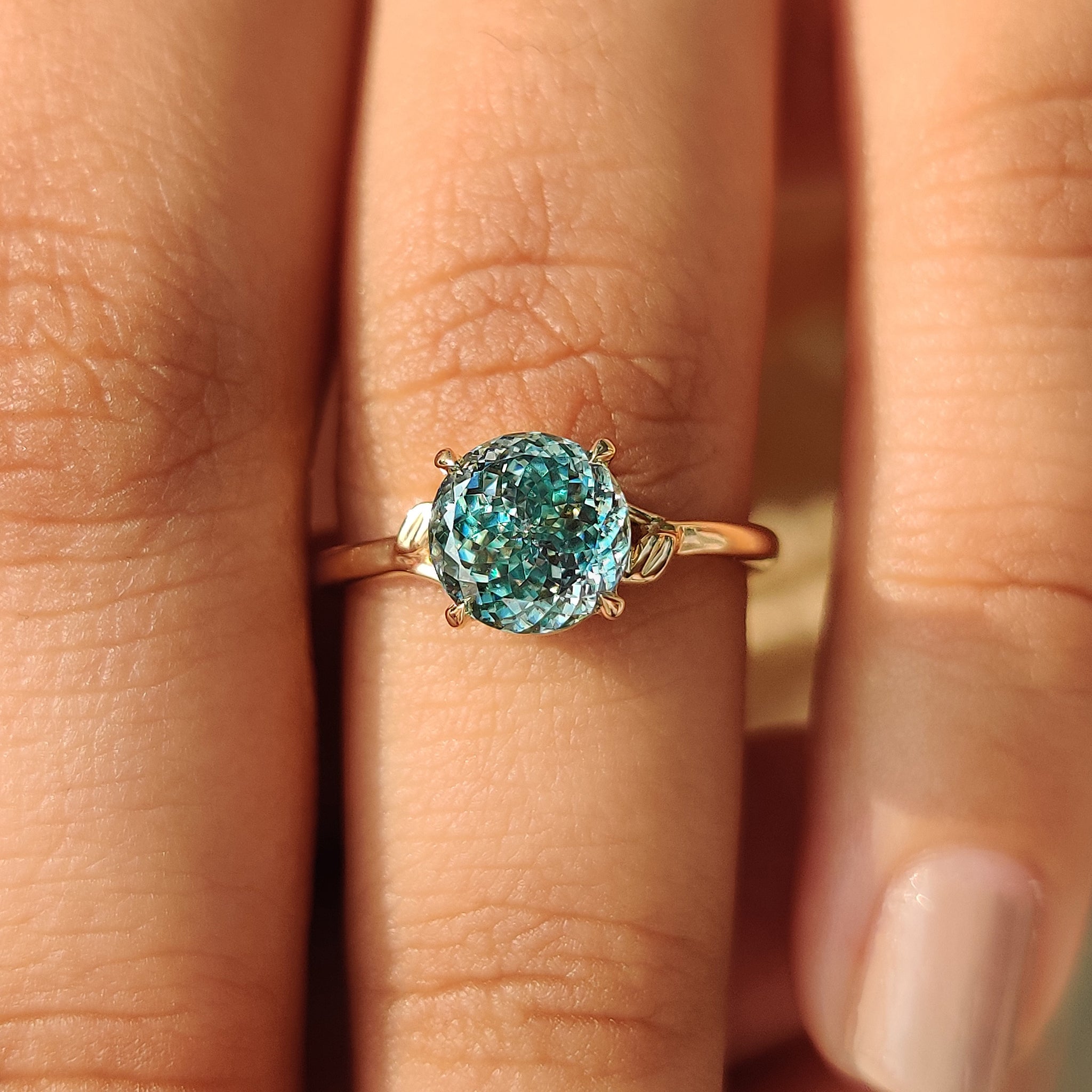 Artisan-made cyan blue moissanite ring with prong setting
