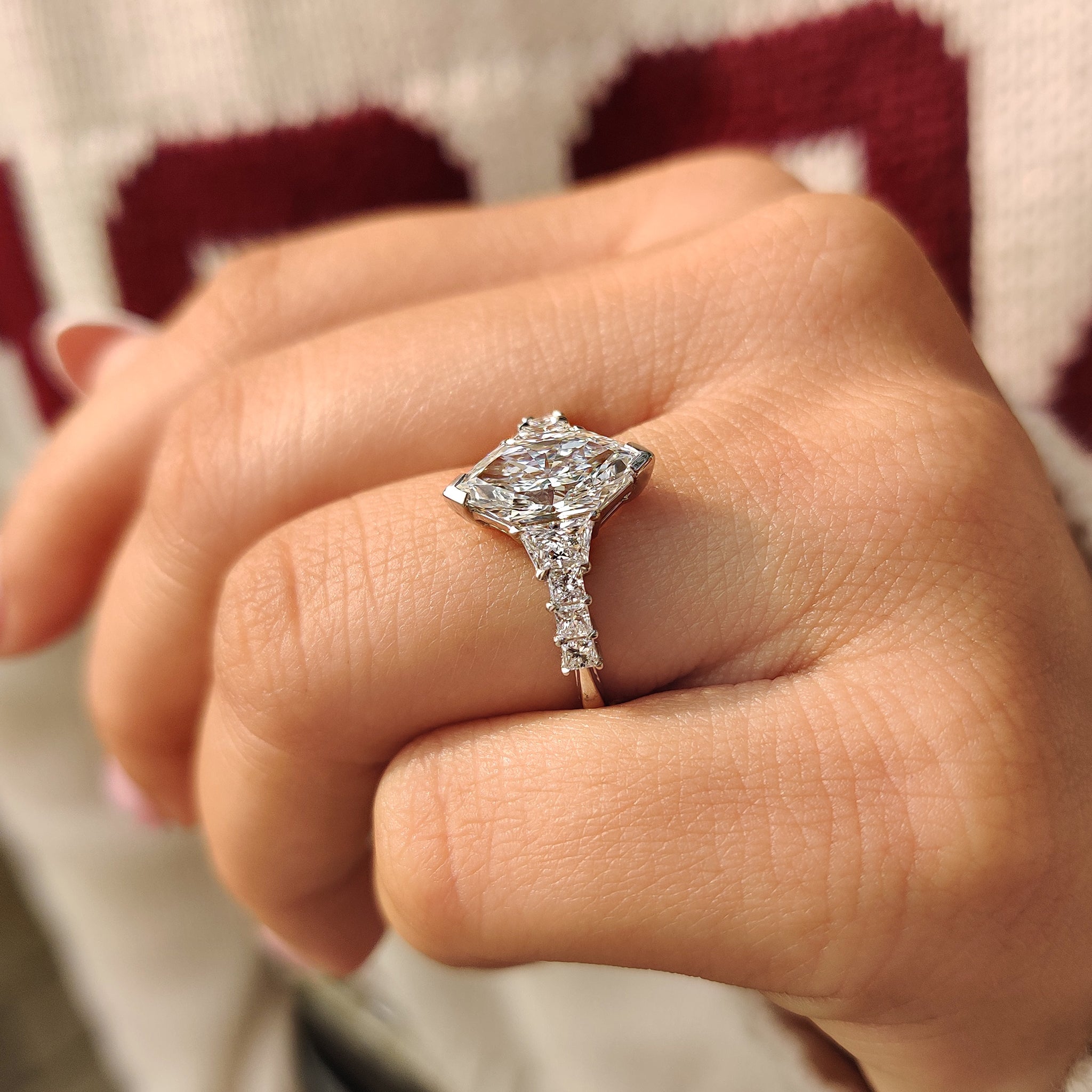 White gold diamond ring featuring trapezoid and princess side stones.
