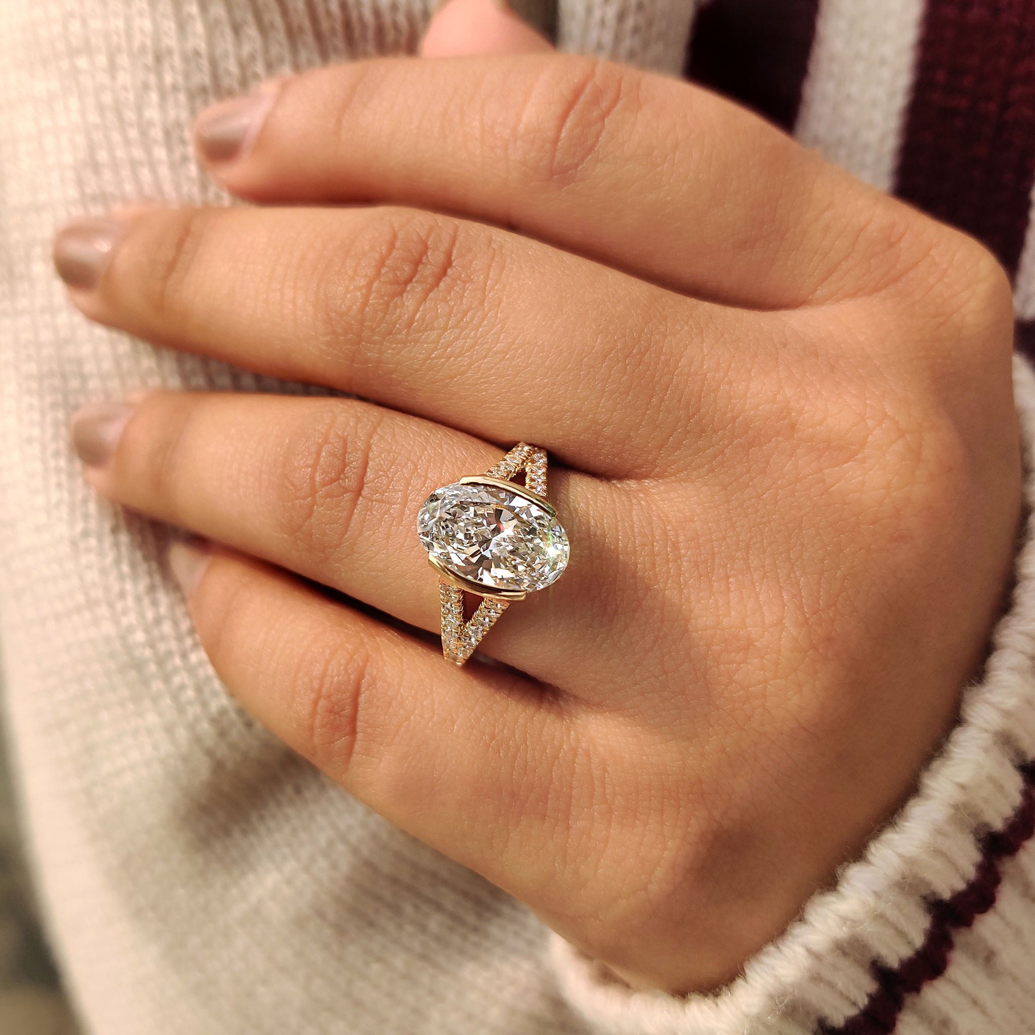 Half bezel oval diamond engagement ring in yellow gold
