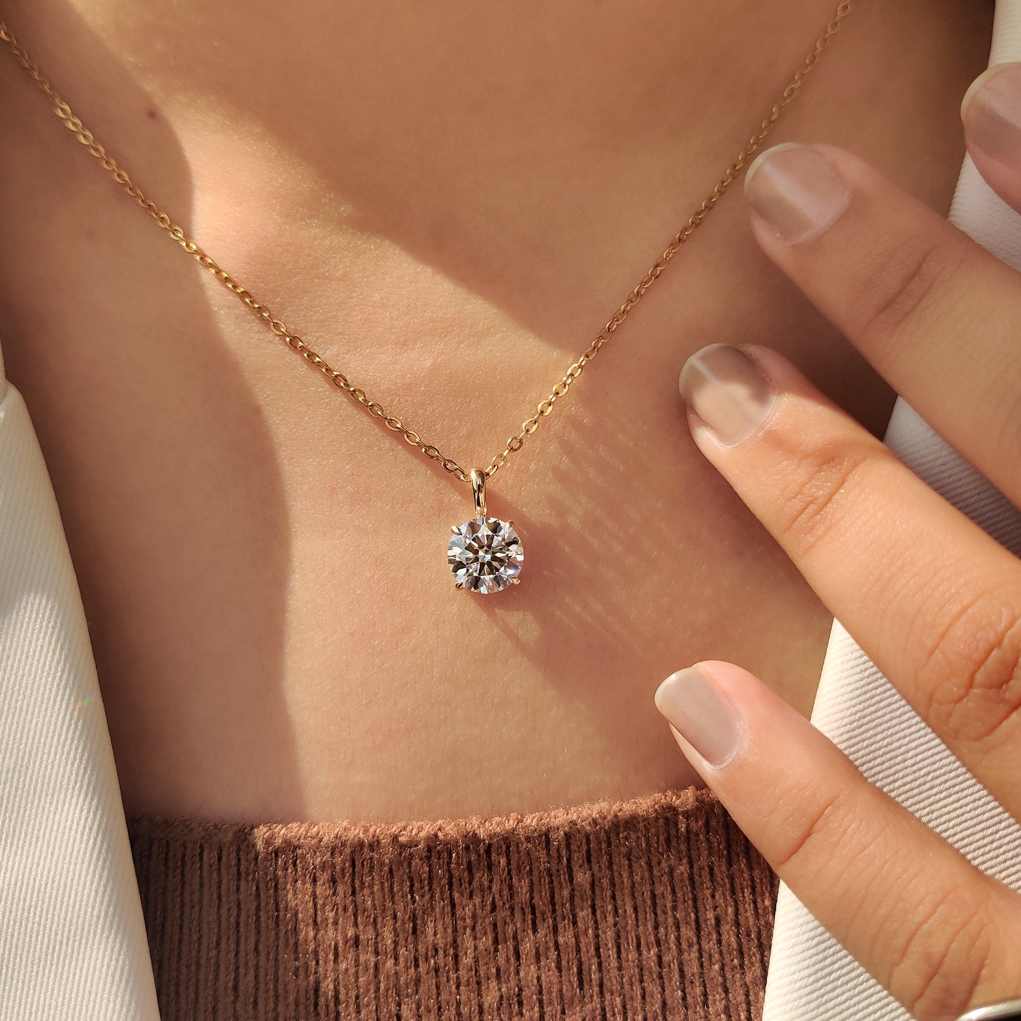 Four claw prong on round diamond pendant.
