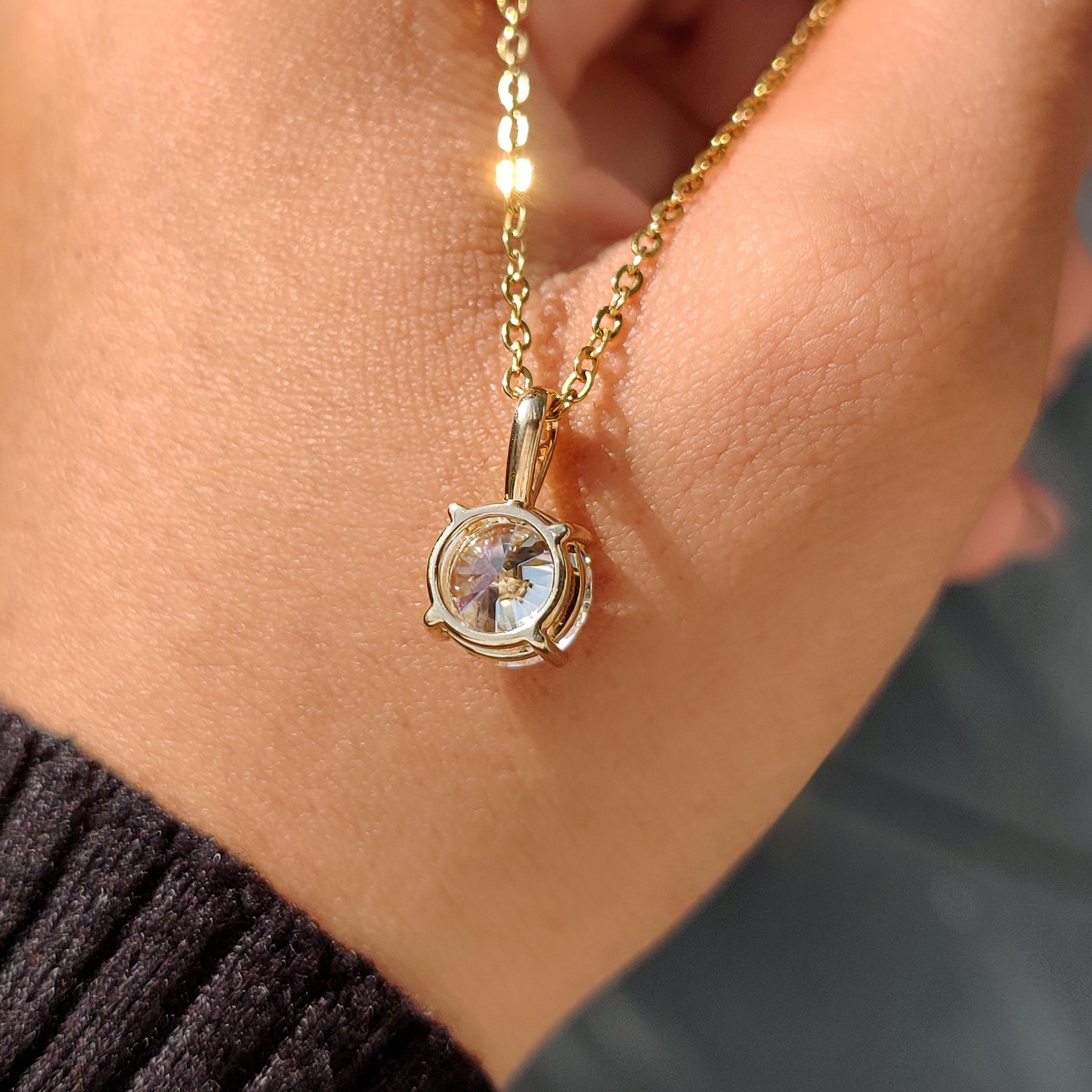 Yellow gold pendant featuring round diamond pendant.
