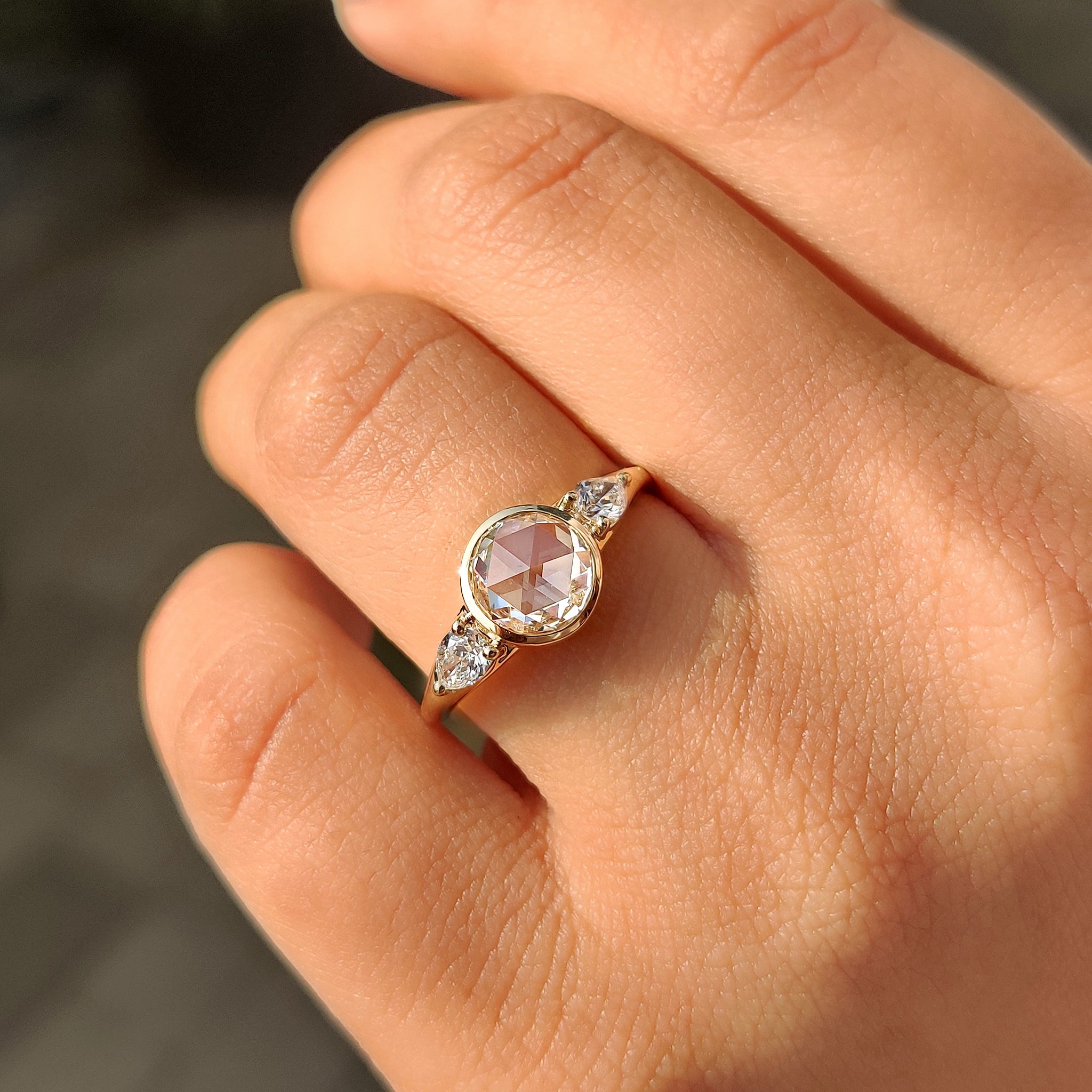 Yellow gold three stone engagement ring with pear accents.