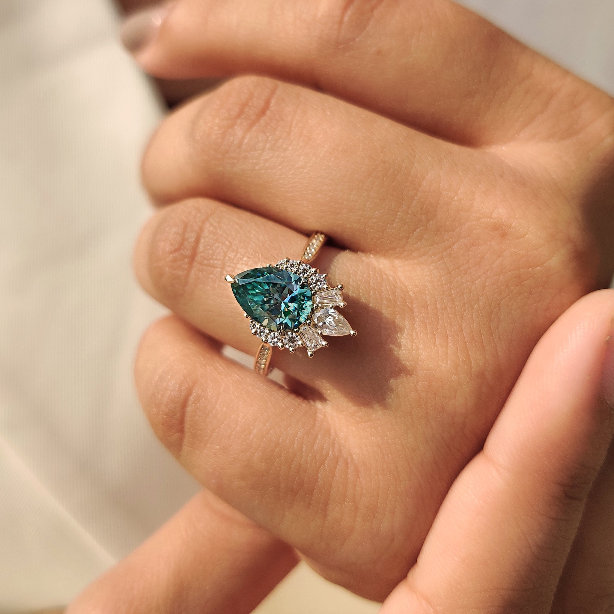 Round side stone ring with a pear center.
