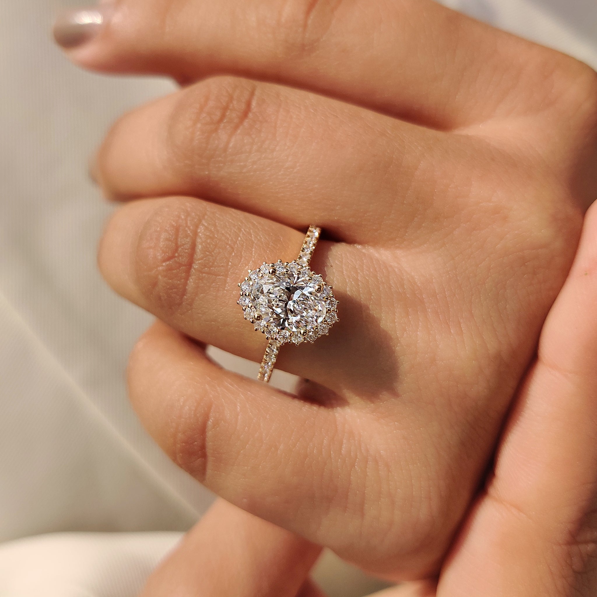 Oval cut diamond ring with halo and pave setting.
