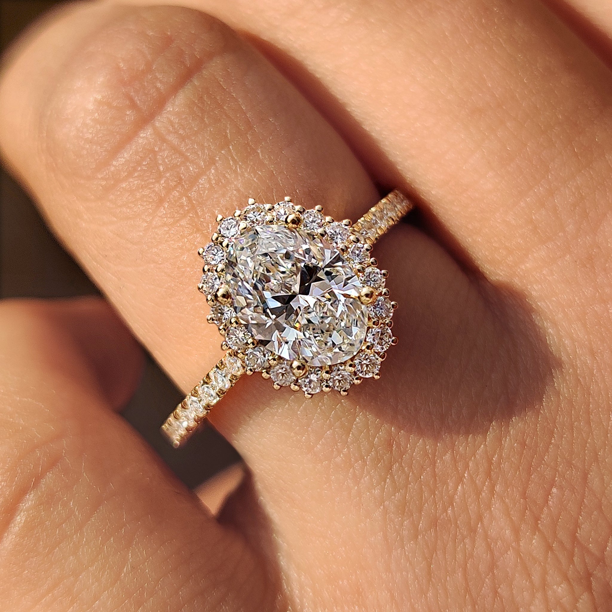 Oval cut diamond engagement ring with round cut halo setting.
