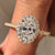 Oval cut diamond engagement ring with round cut halo setting.
