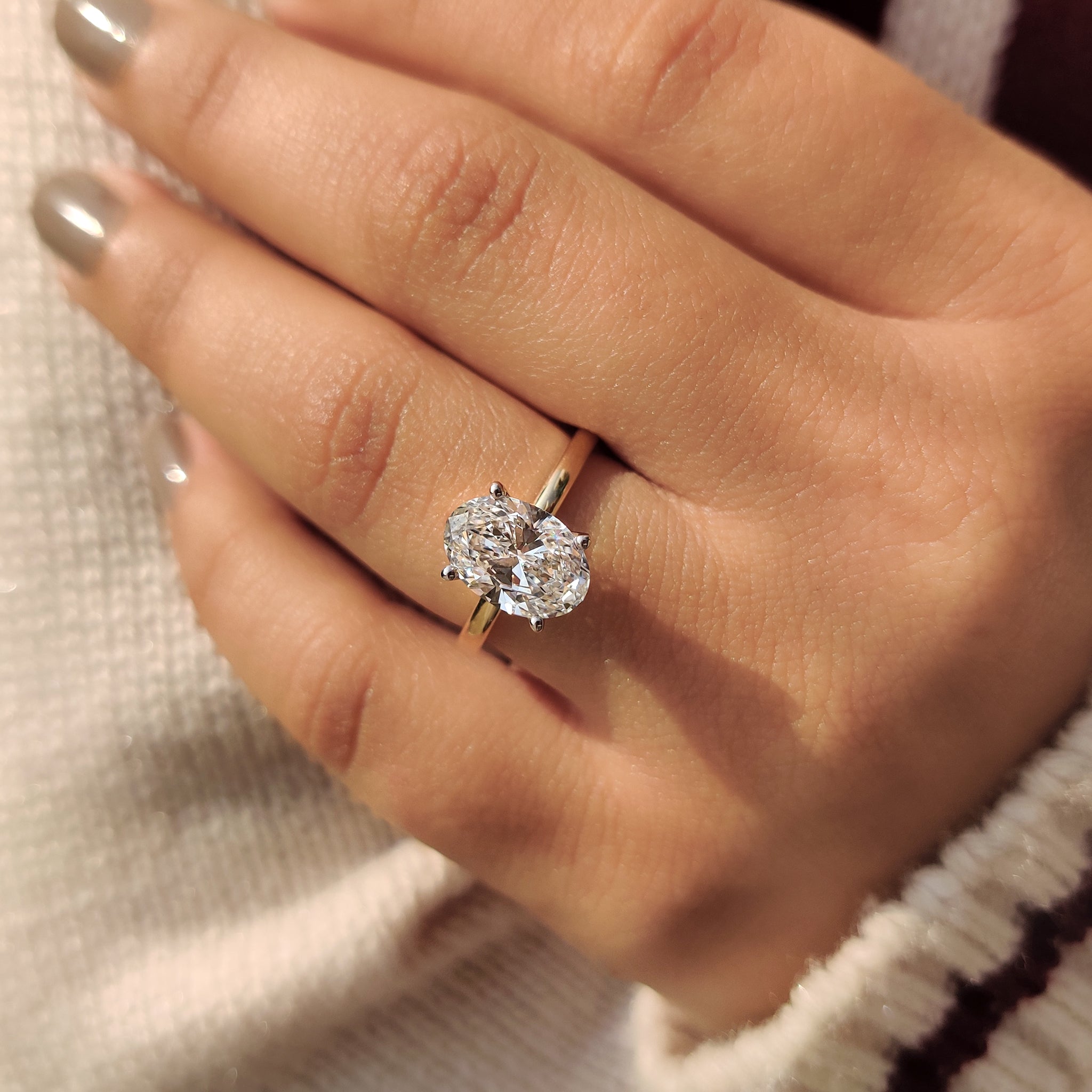 Oval diamond engagement ring with a four prong setting.
