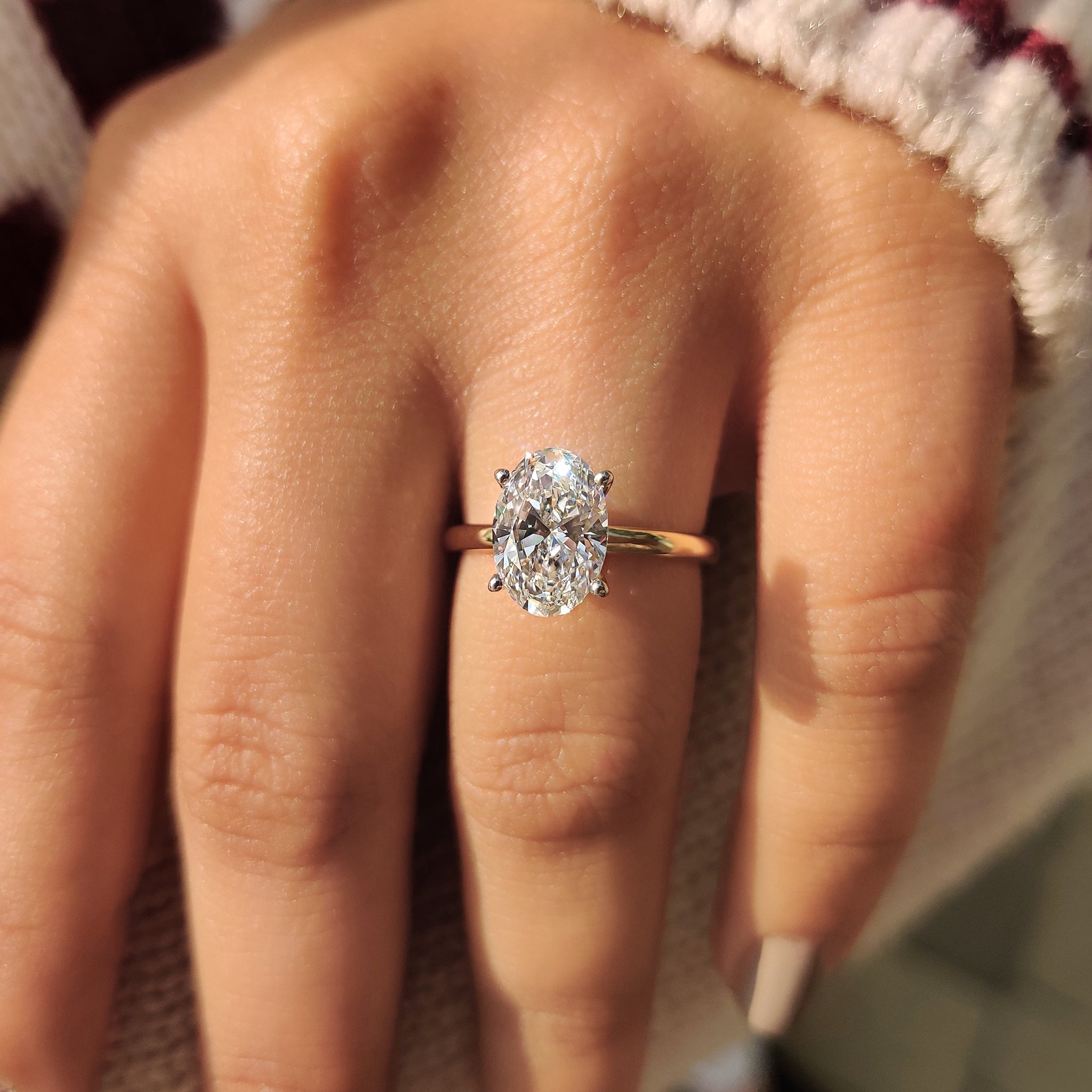 Two tone engagement ring with an oval cut stone.
