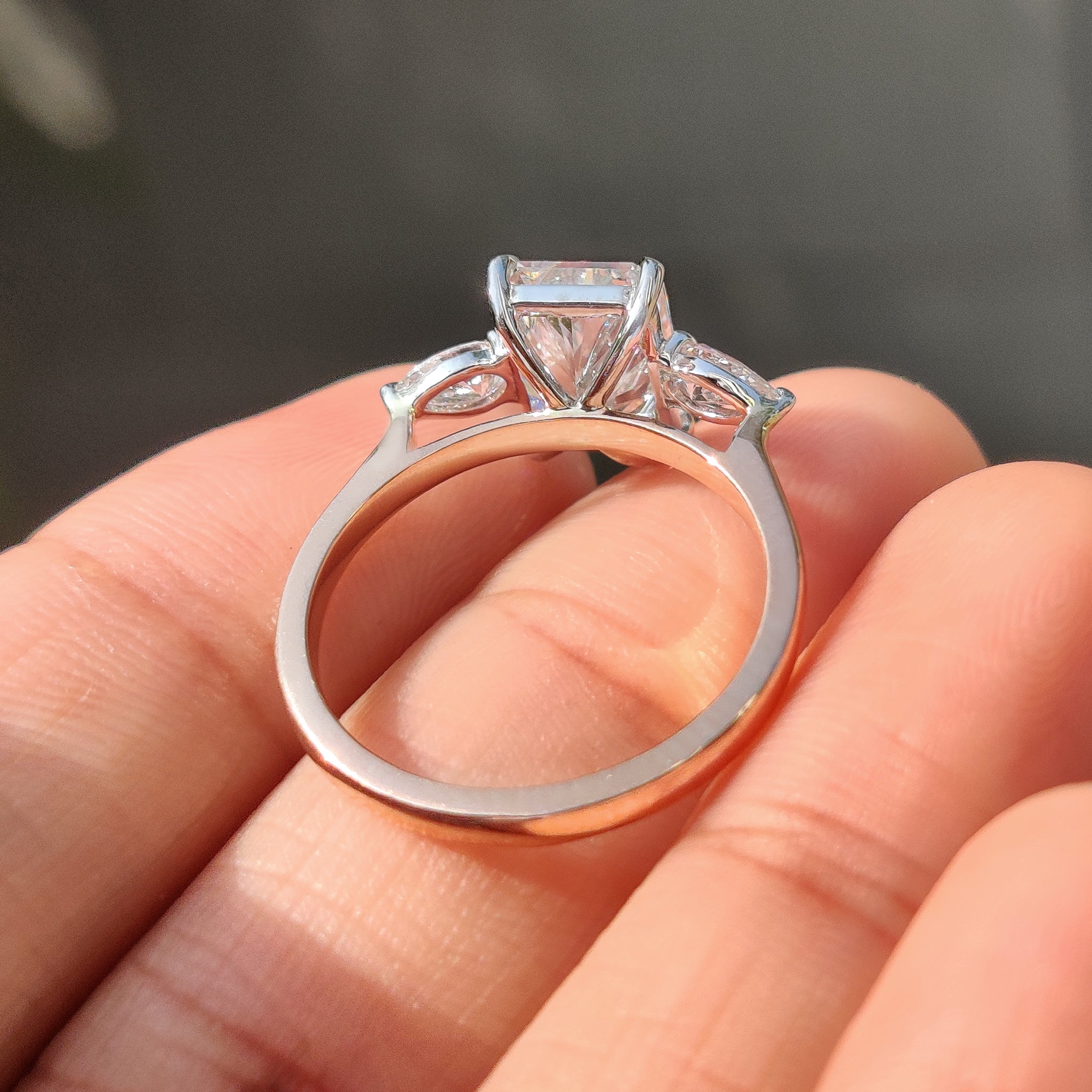 Buy diamond ring with radiant cut and pear side stones.
