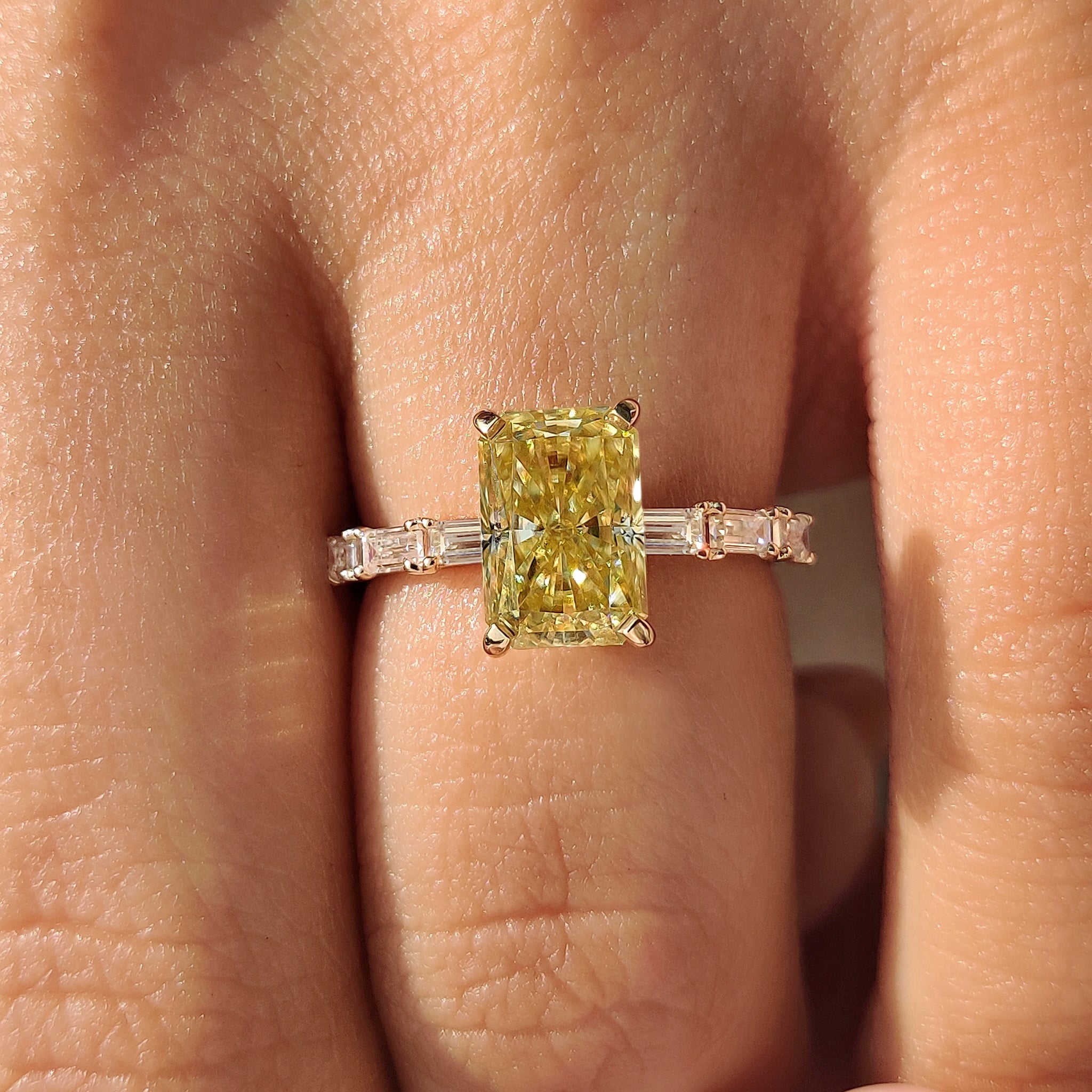 Custom yellow moissanite ring featuring four tab prong setting.
