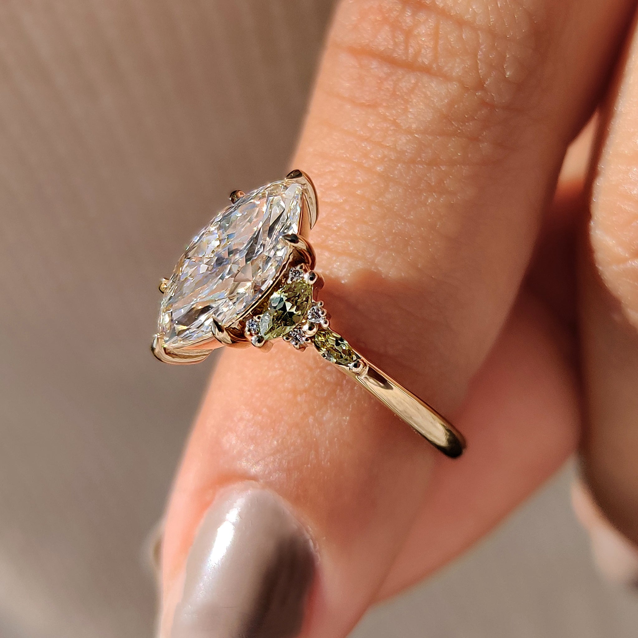 Marquise diamond ring with green marquise side accent stone.
