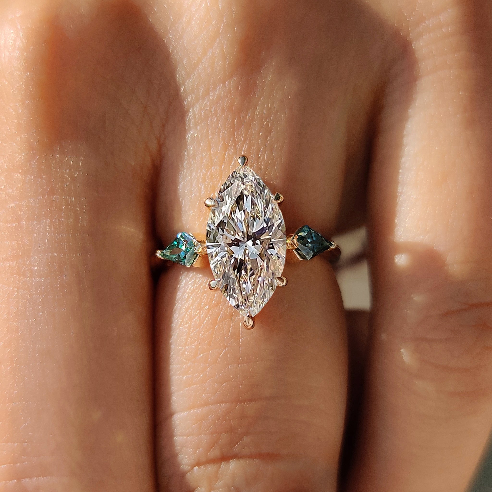 Cyan blue ring with marquise cut diamond design.
