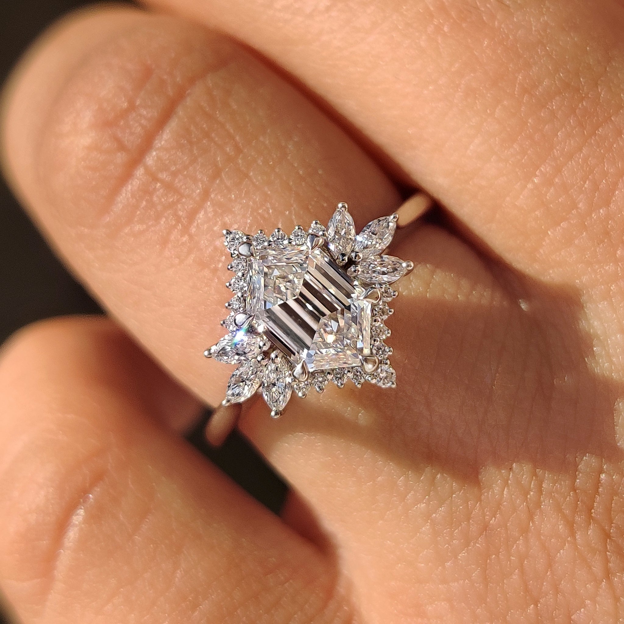 Elongated hexagon engagement ring with marquise side stone accents.
