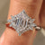 Elongated hexagon engagement ring with cluster setting design.
