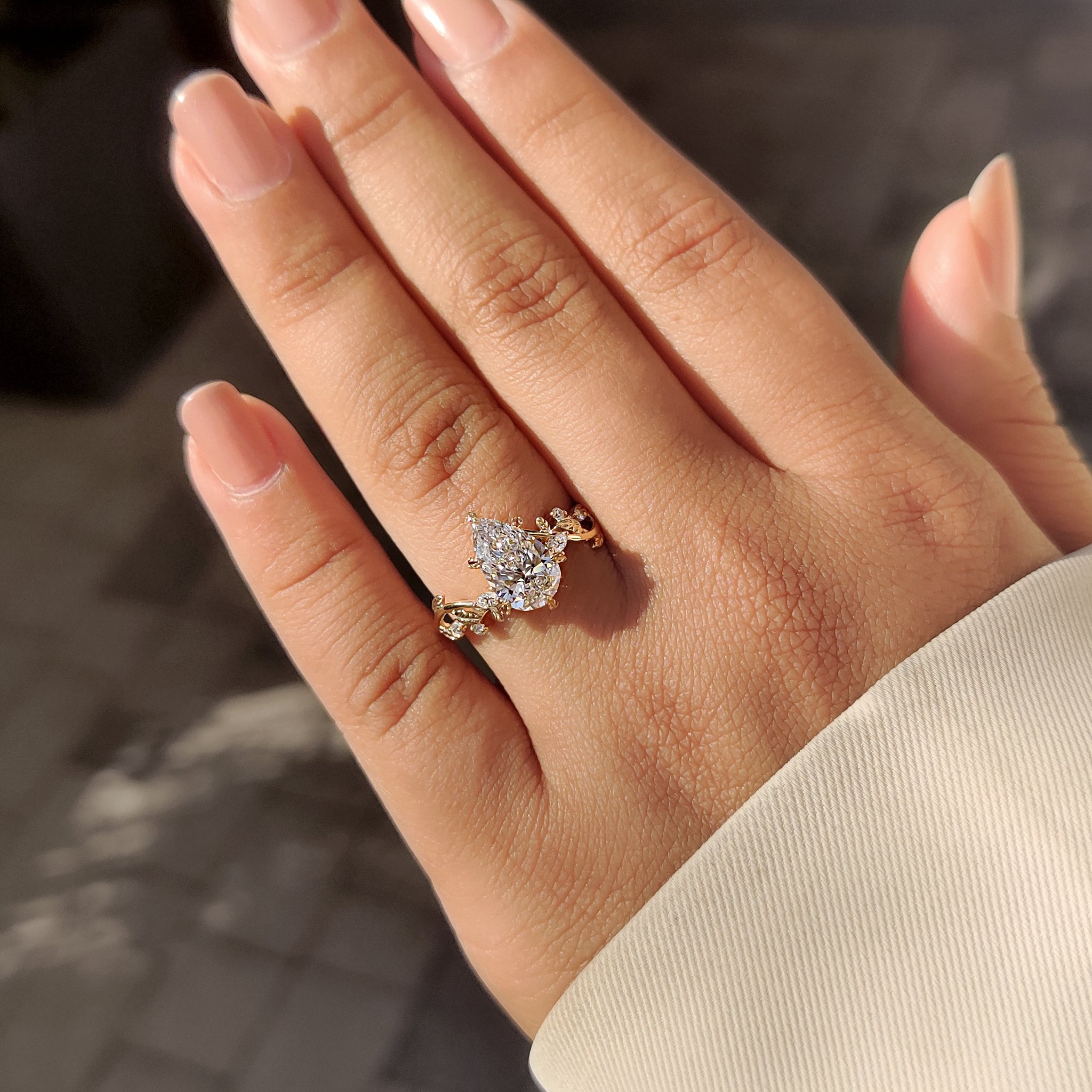Custom diamond ring with pear diamond and nature inspired design.