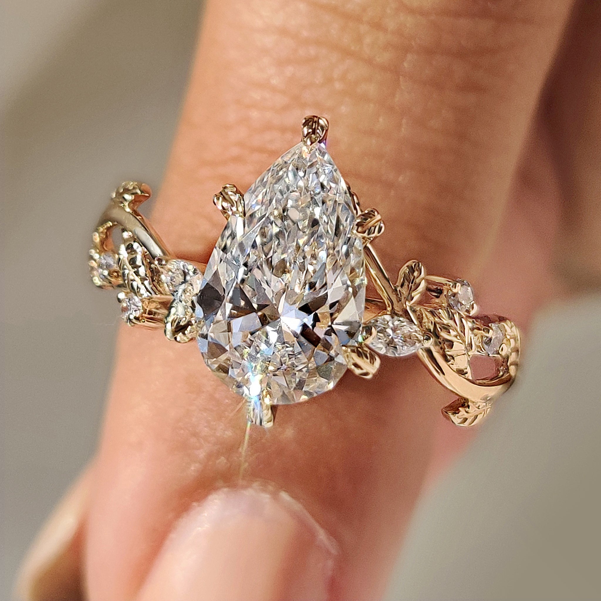 Nature inspired engagement ring with pear diamond and filigree details.
