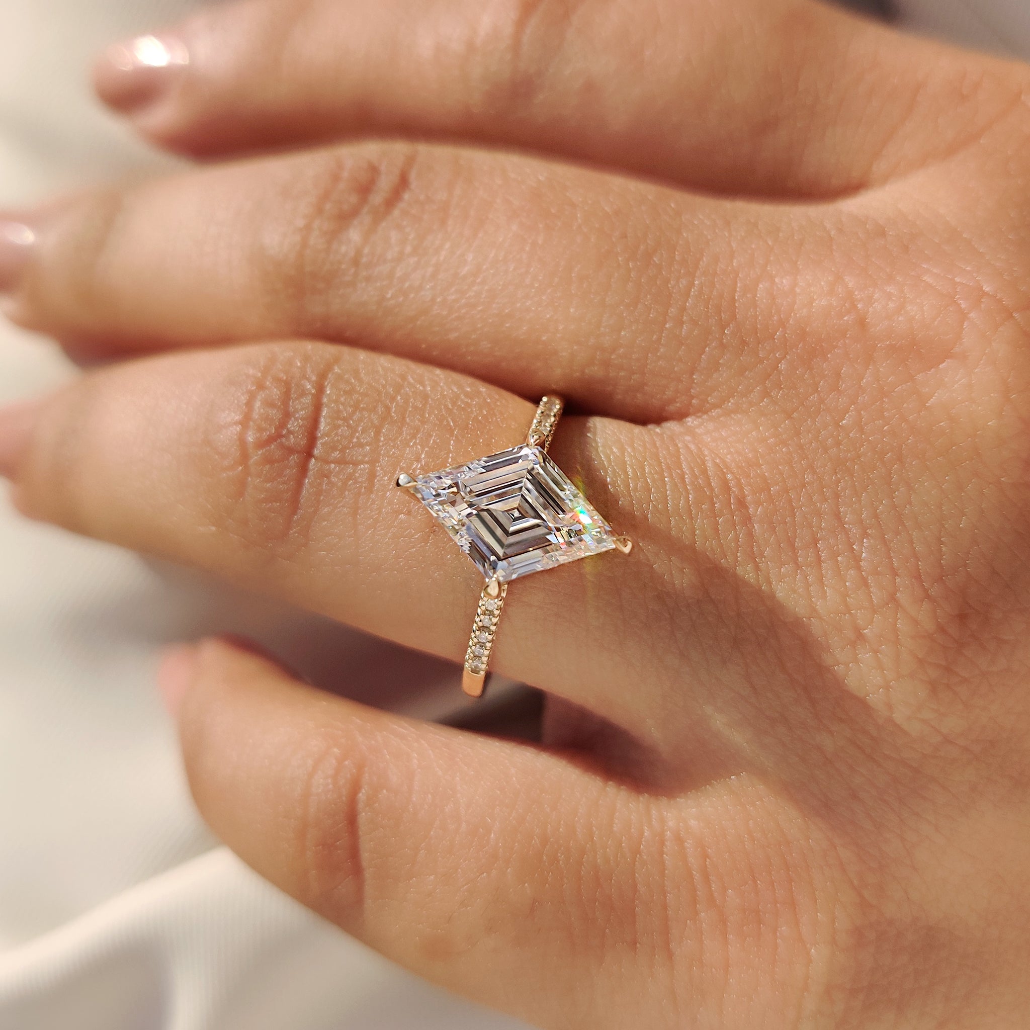 Lozenge cut ring with round diamond pave band.
