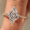 Lozenge cut diamond ring with pave band and round diamonds.
