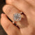 Round diamond ring with cathedral and halo design.
