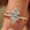 Marquise diamond ring with flush pave setting ring and round cut side diamond.
