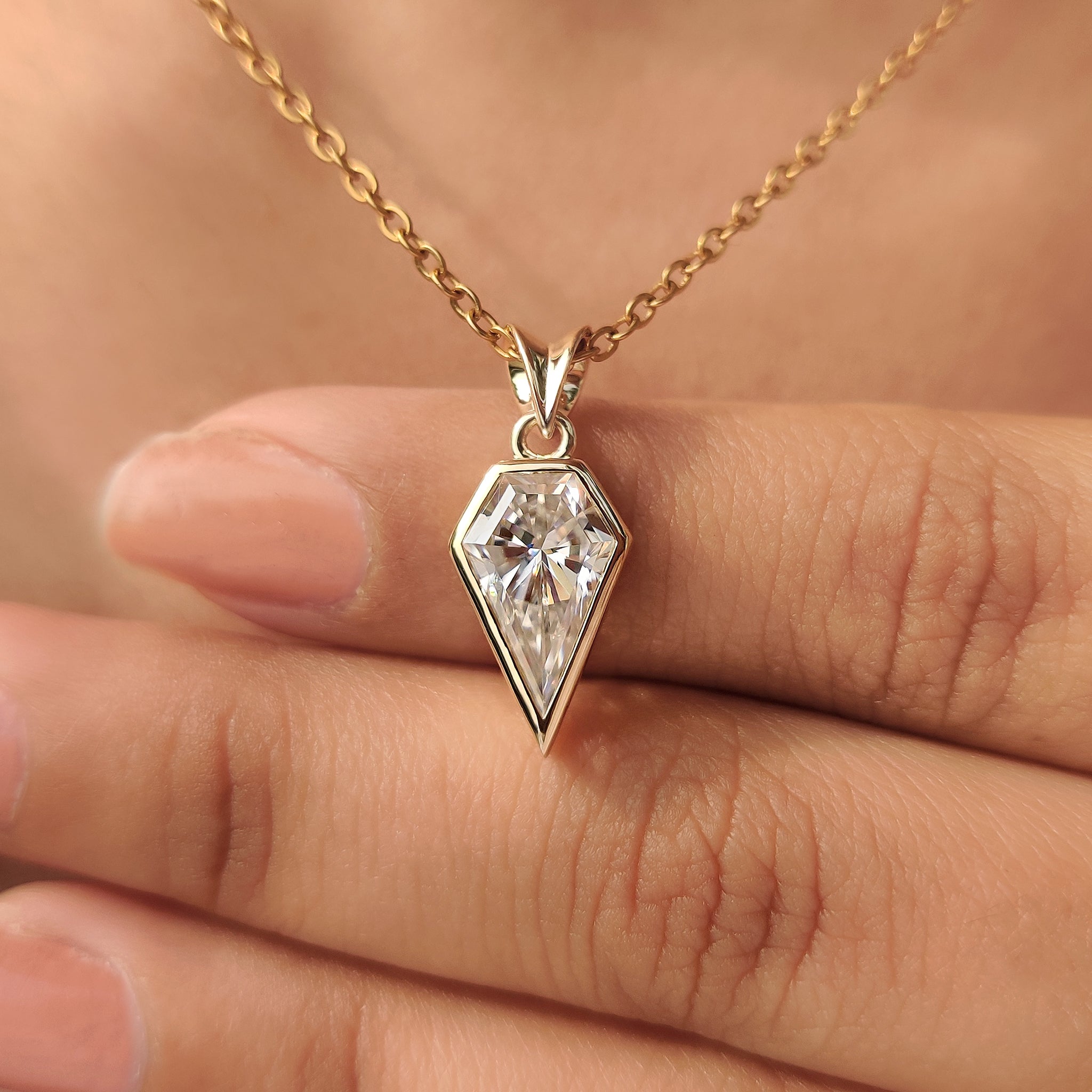 Spear cut moissanite pendant with bezel setting.
