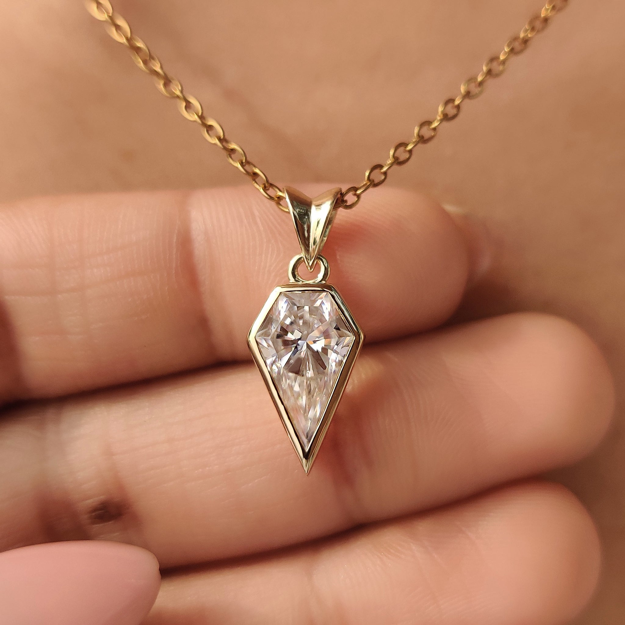 Bezel set spear cut moissanite solitaire pendant.
