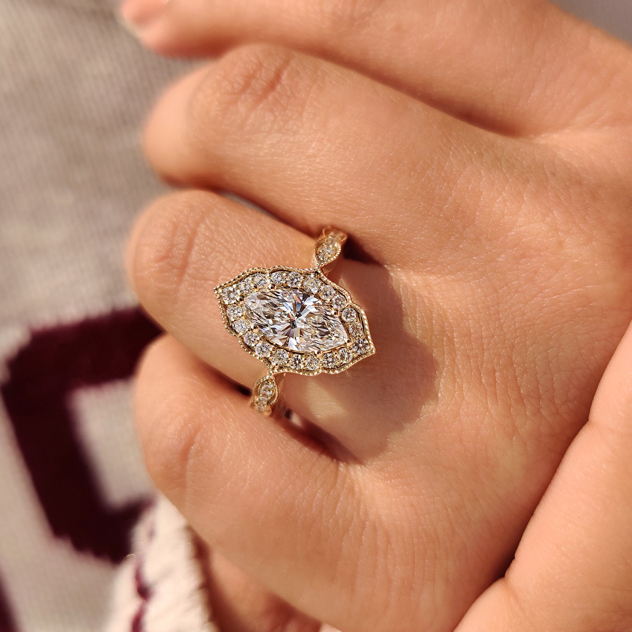 Marquise cut diamond ring with milgrain and halo accents.
