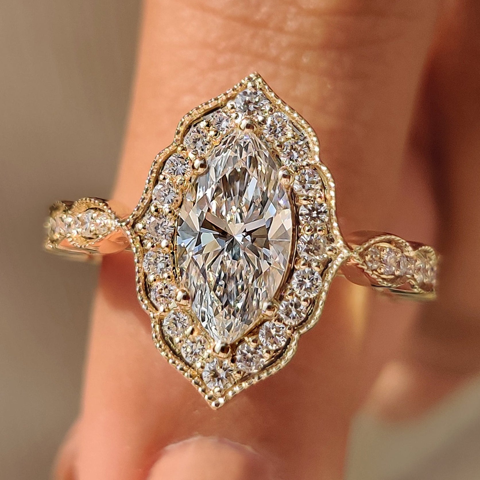 Marquise cut diamond ring with halo style and round diamonds.
