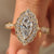 Marquise cut diamond ring with halo style and round diamonds.
